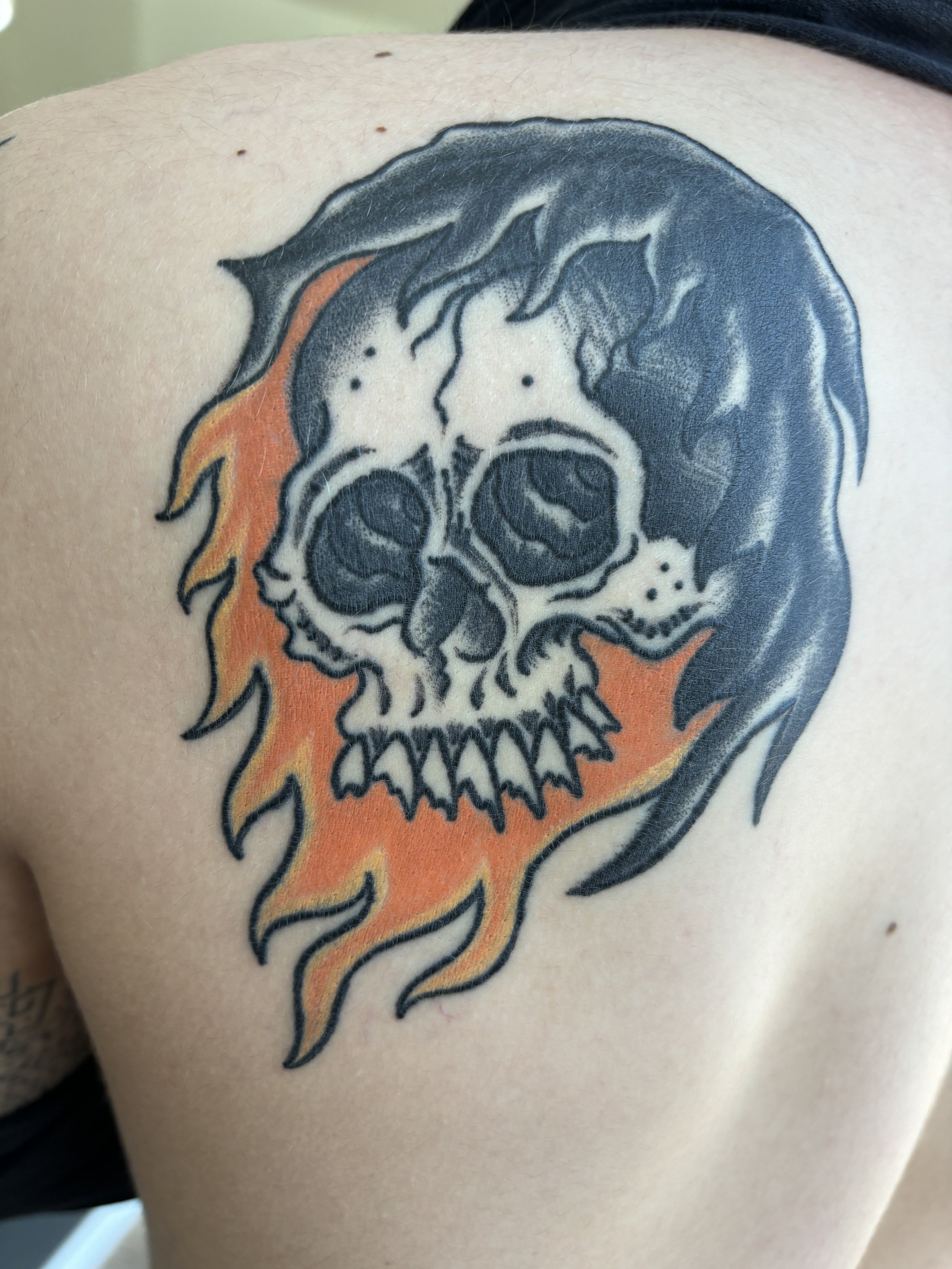 Tattoo of a skull with flames on skin