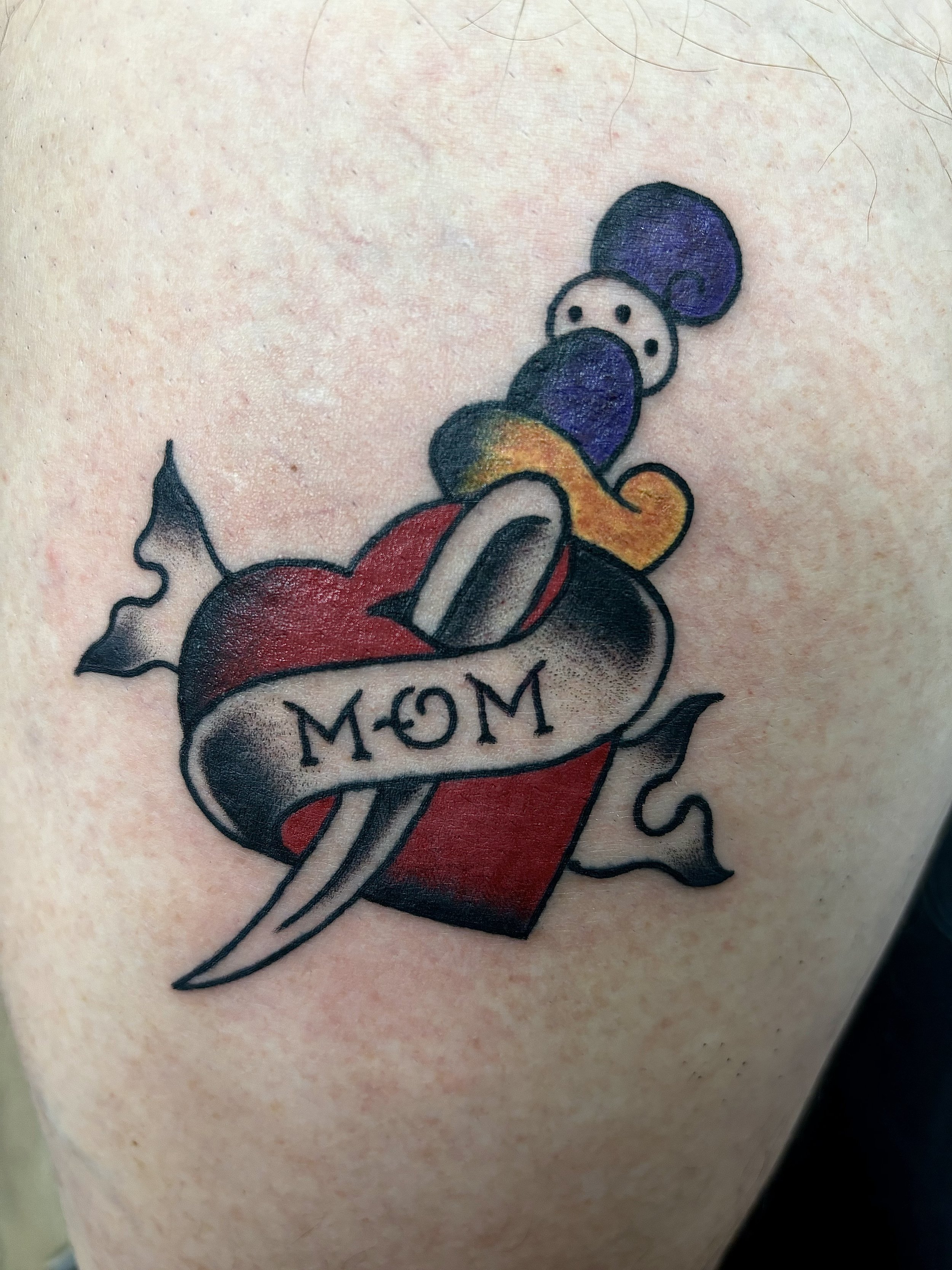 Tattoo of a heart with a dagger and "MOM" banner