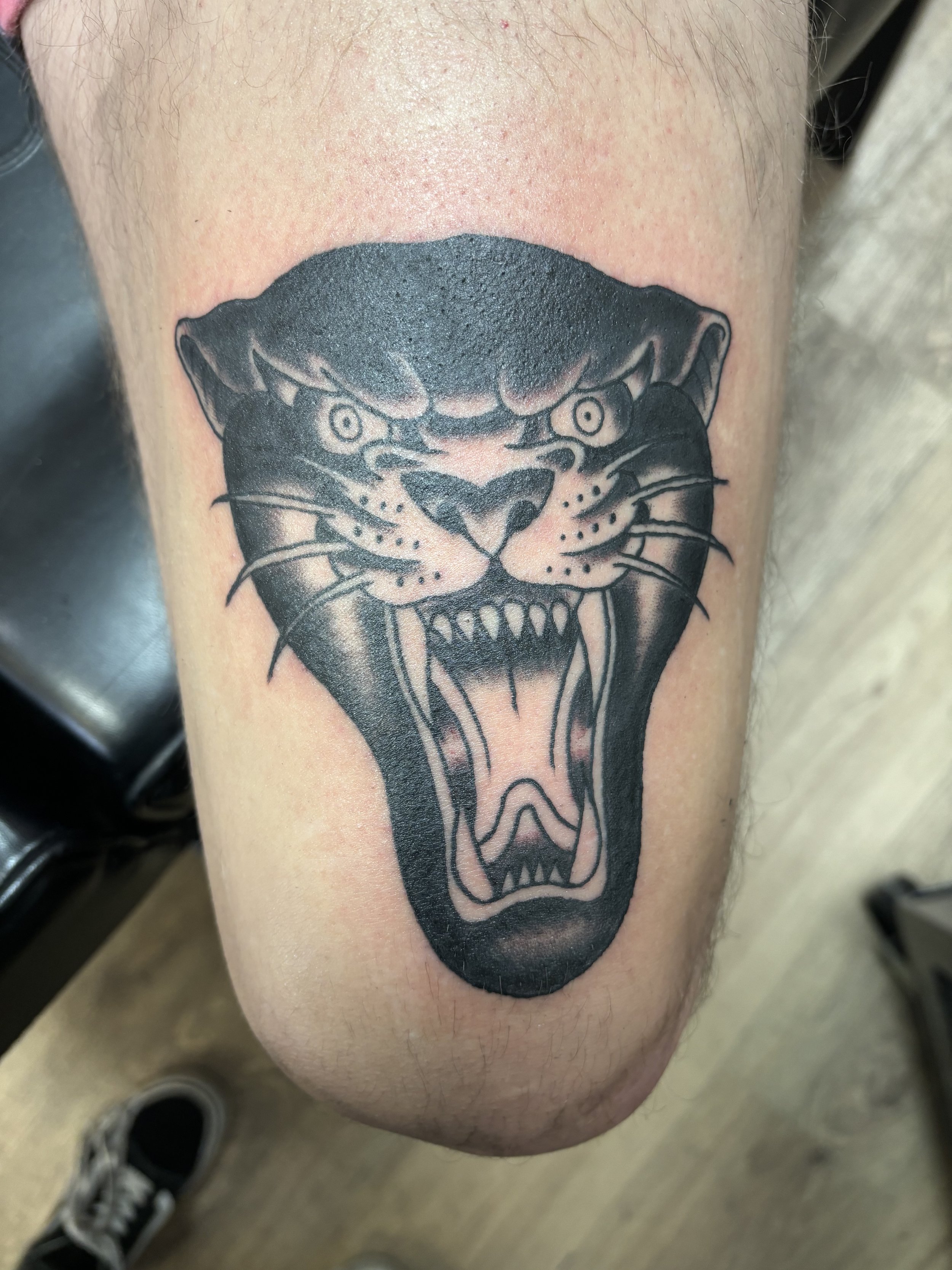 Tattoo of a roaring black panther on a person's skin