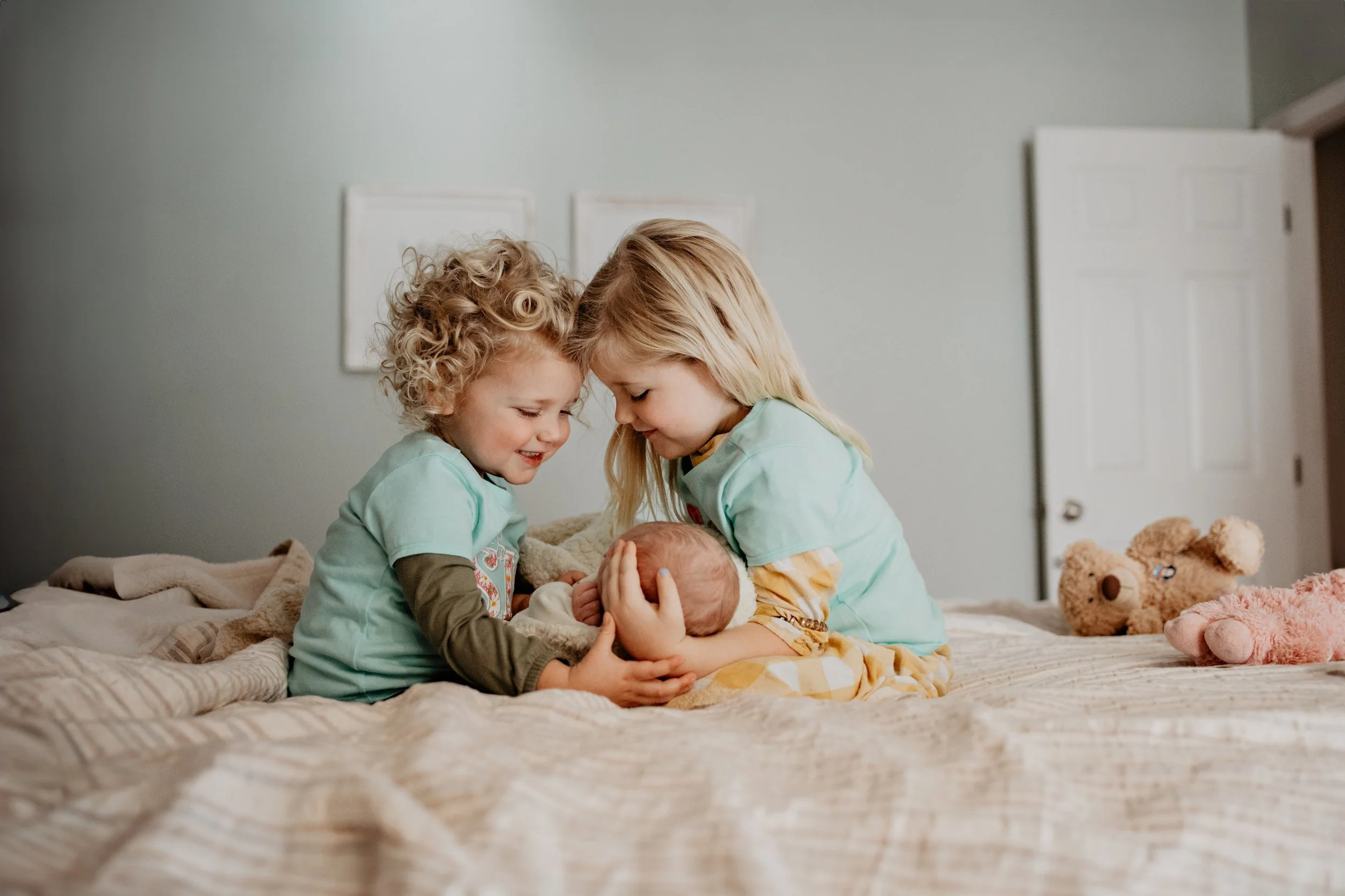 Big sisters loving on their new baby brother