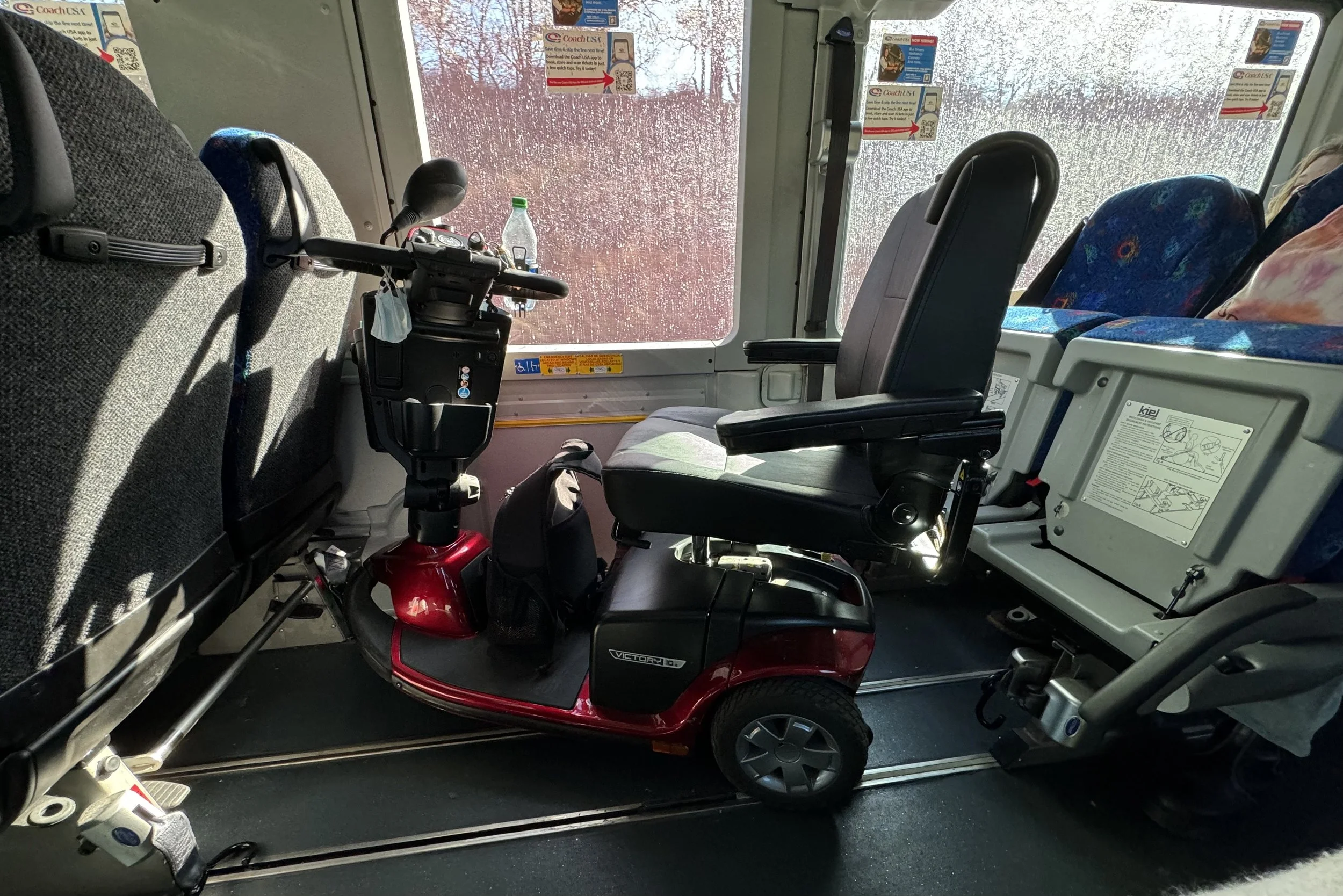 My scooter snuggly parked after two seats were pushed back.