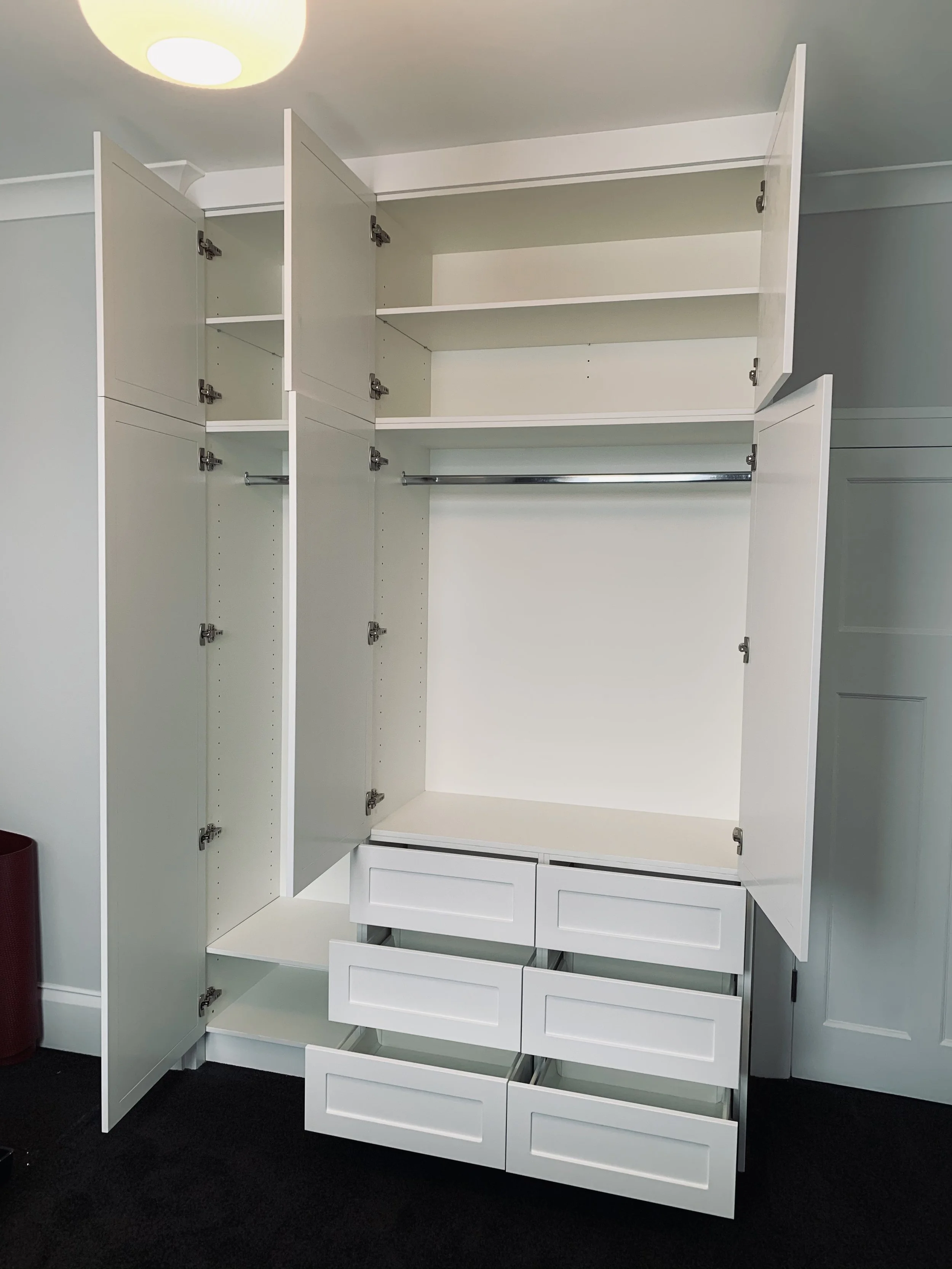 White wardrobe with doors and drawers open showing storage space