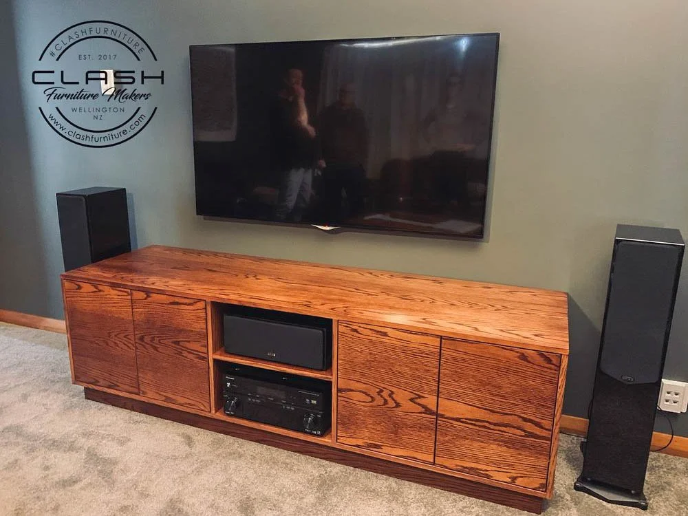 Stained American ash entertainment unit with cabinet and shelves, displaying stereo system and a wall hung tv above