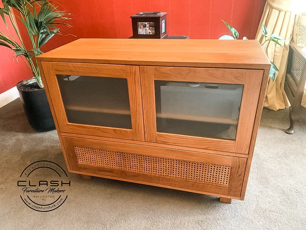 Wooden entertainment unit with glass door display cabinets and a pull out draw at the bottom of the unit 