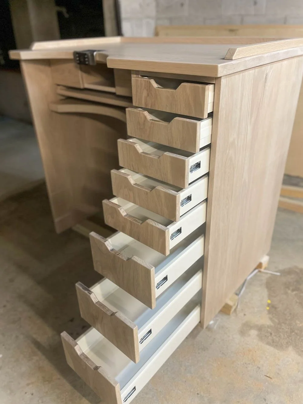 American oak jeweller's with cut outs at the tops of the drawers to act as handles. Drawers are open to show the storage space 