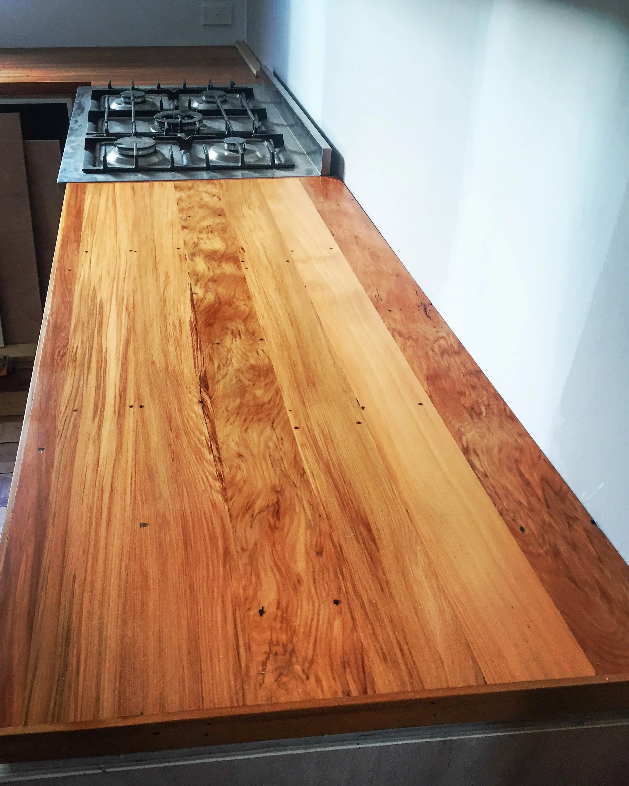 Recycled rimu benchtop with gas stove cook top