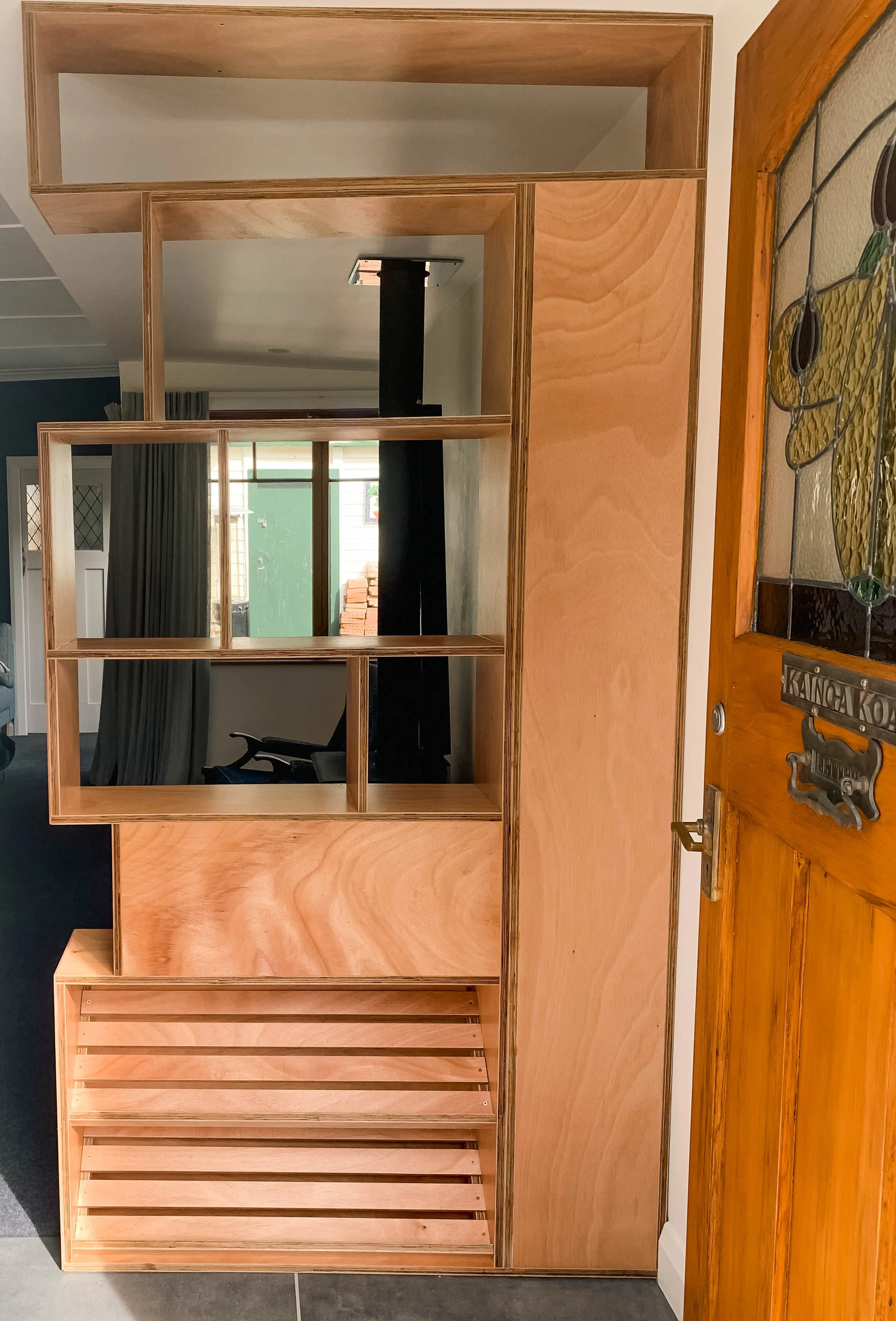 Plywood room divider with shelving compartments 