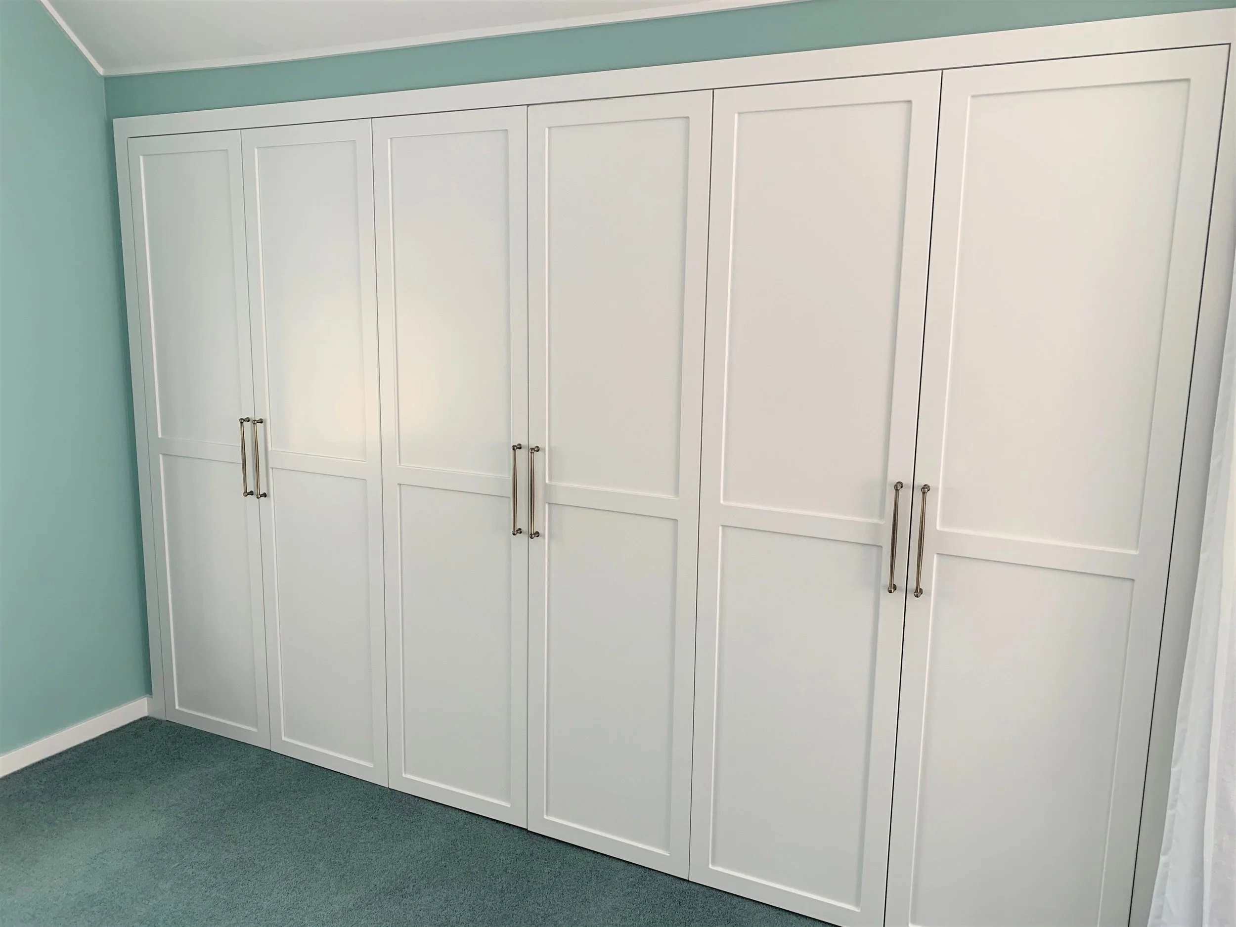 White panel door wardrobe with handles on 3 pairs of doors