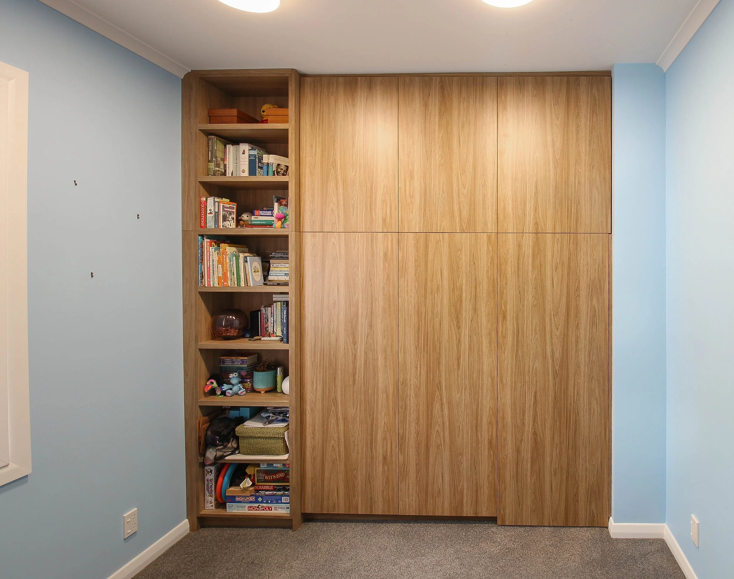 Flat door wardrobe with built in bookcase on left hand side. 