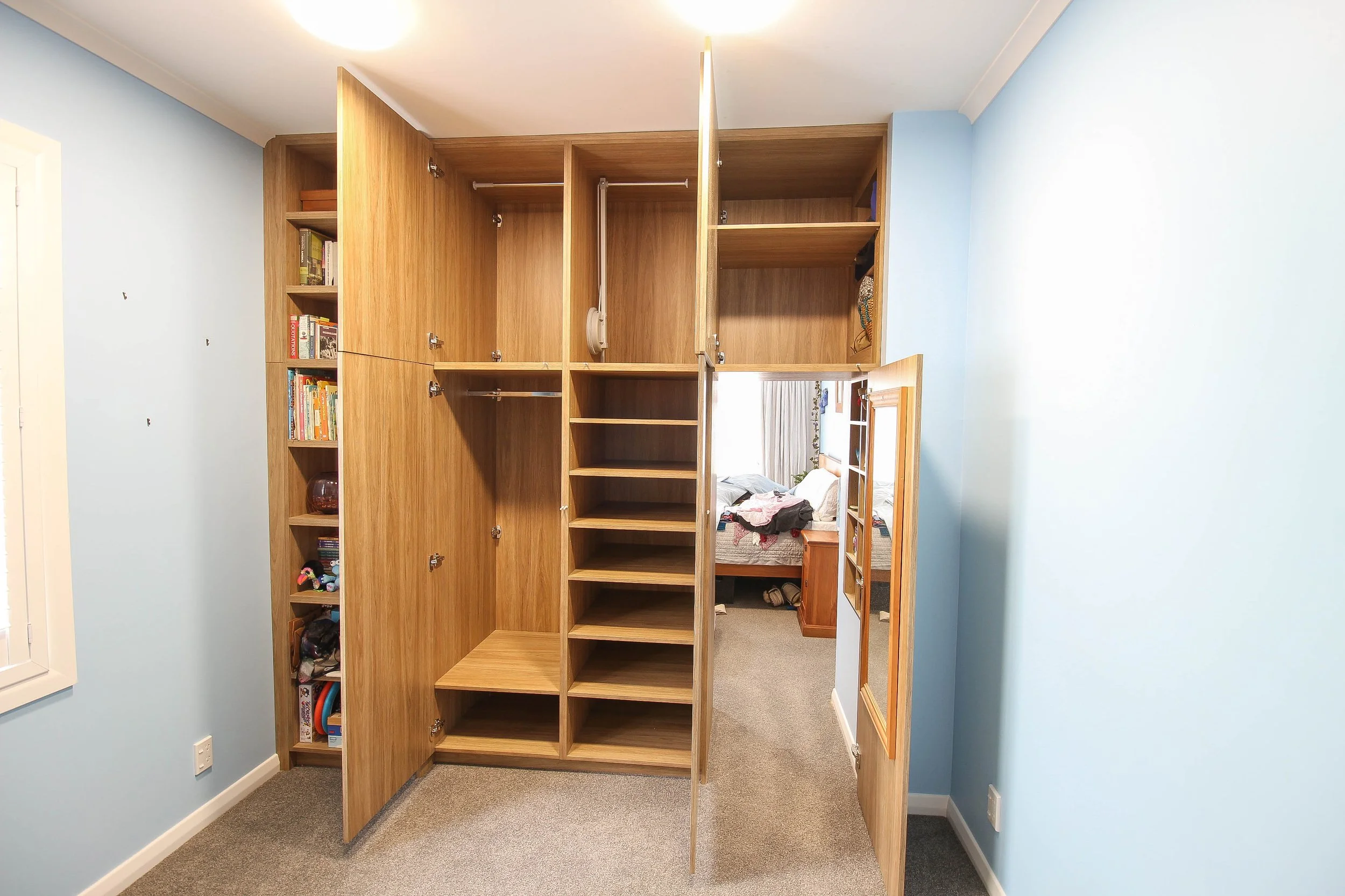 Flat door wardrobe with built in bookcase with all doors open