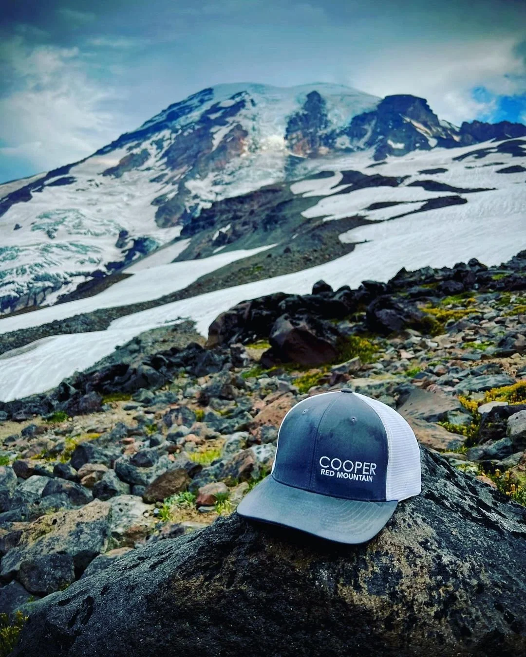 Cooper Wine hat in front of a snowy mountain