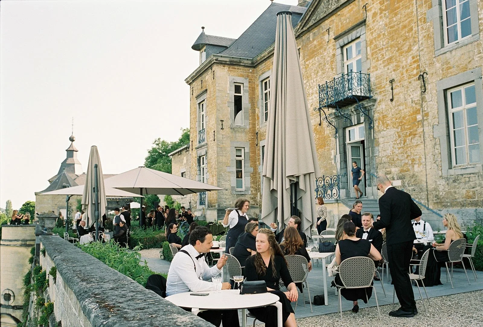 Wedding guests sitting at Chateau Neercane's Outdoor terrace