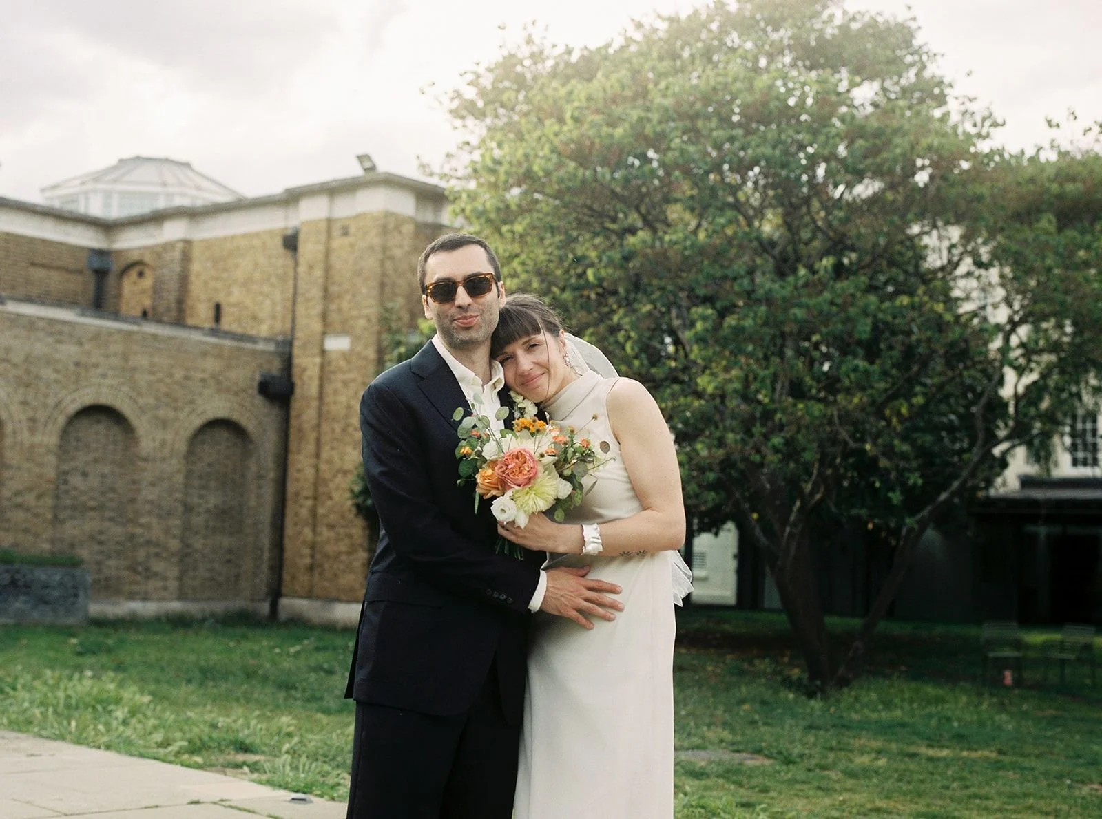 Bride and groom embrace for a timeless portrait in front of Dulwich Picture Gallery just before their wedding ceremony.