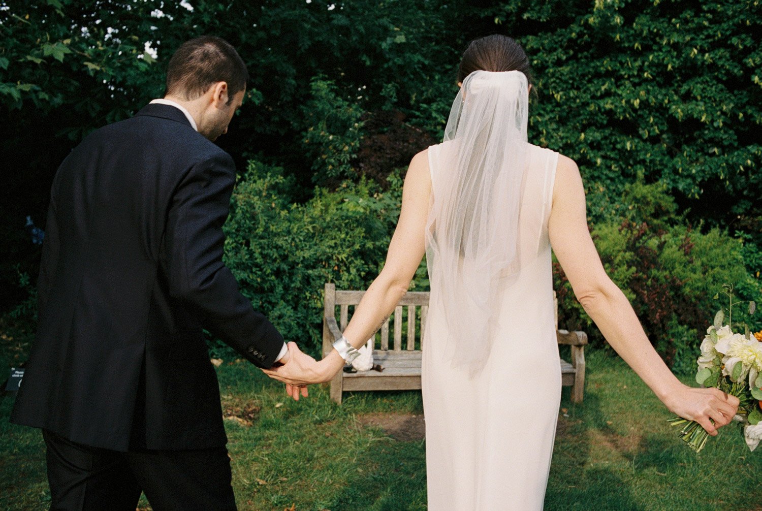 romantic, vintage looking scene of bride and groom walking in a private garden, on Portra 400 film by Provence wedding photographer