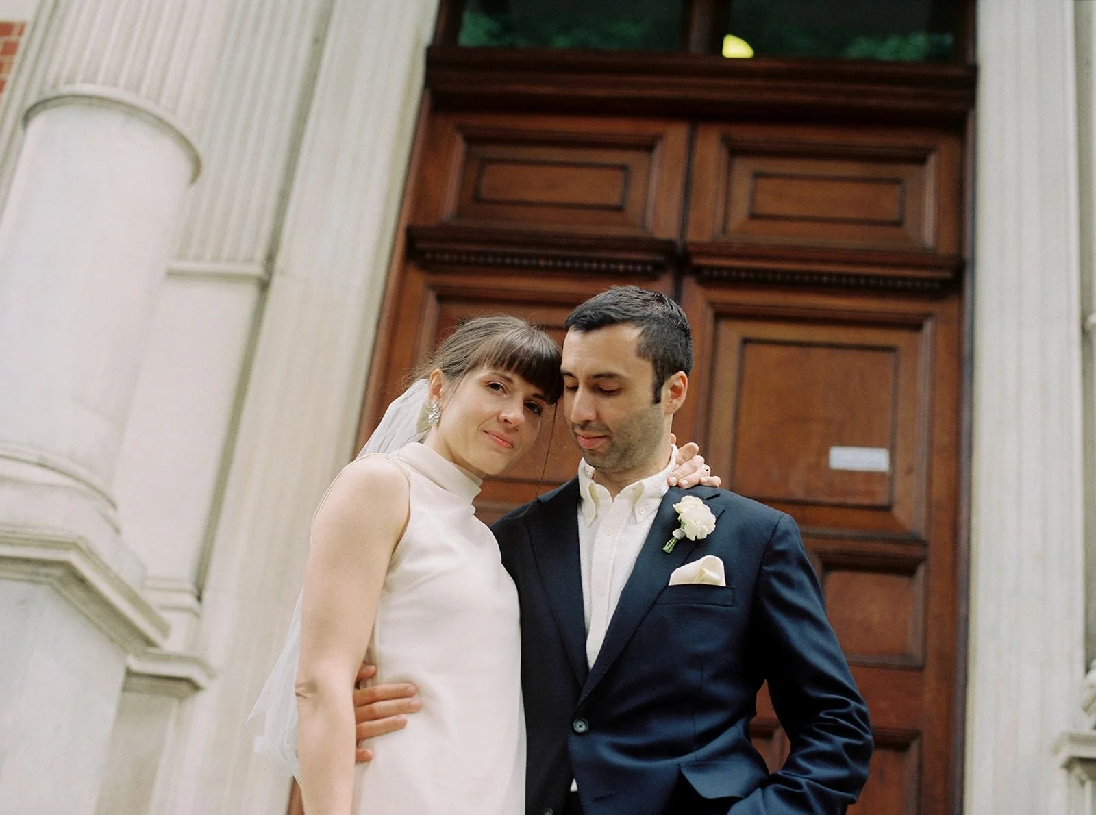 Timeless portrait of bride and groom embracing, photographed on film