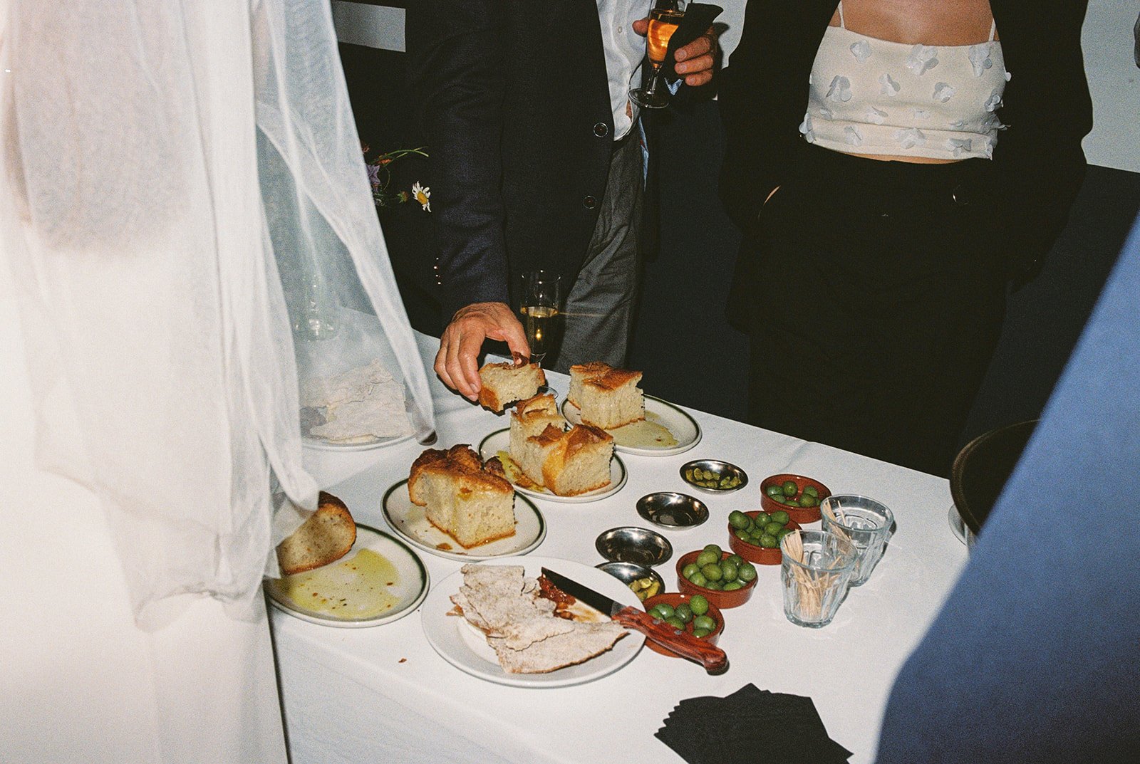 A wedding table with bread, dips, olives, and drinks, captured on film in France.