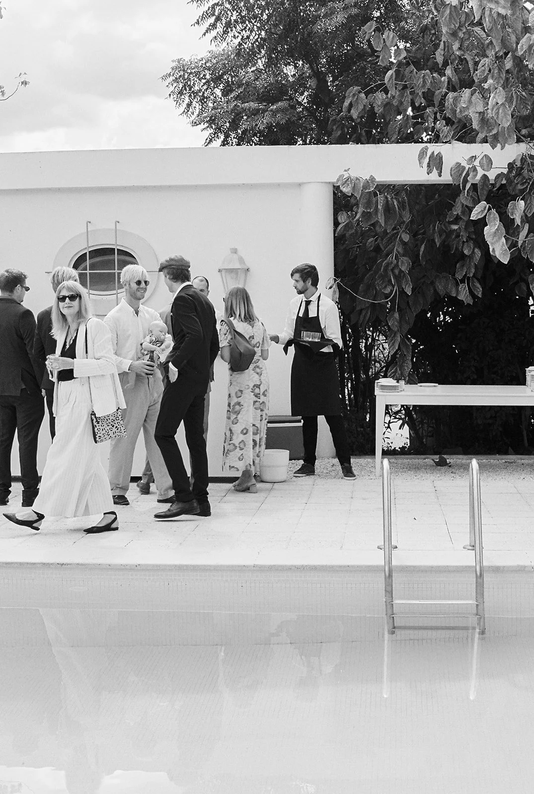 Guests at Algarve wedding by the pool in black and white 35mm film.