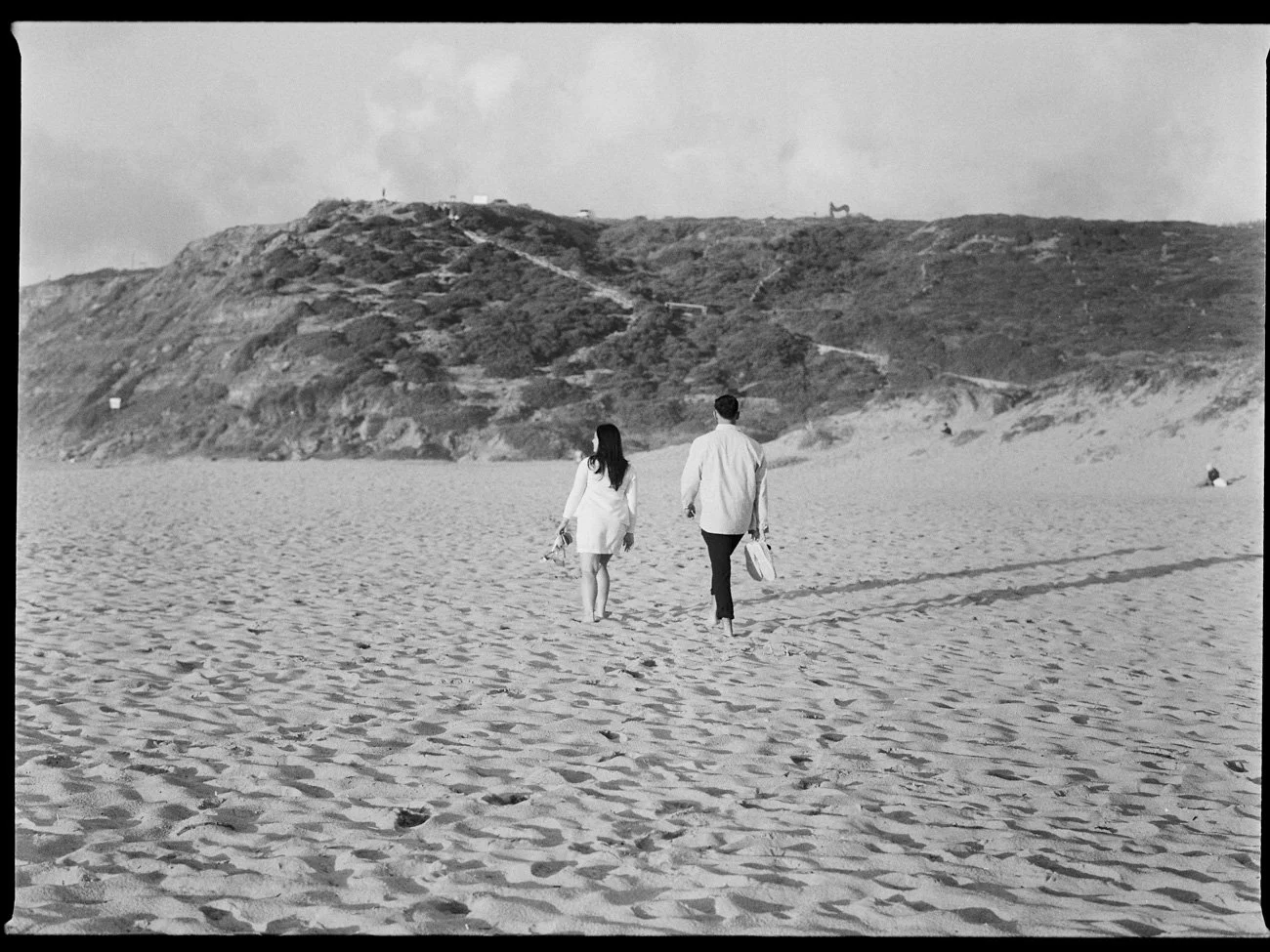 Couple walking casually on the beach, on BW film during an engagement shoot in Lisbon, Portugal