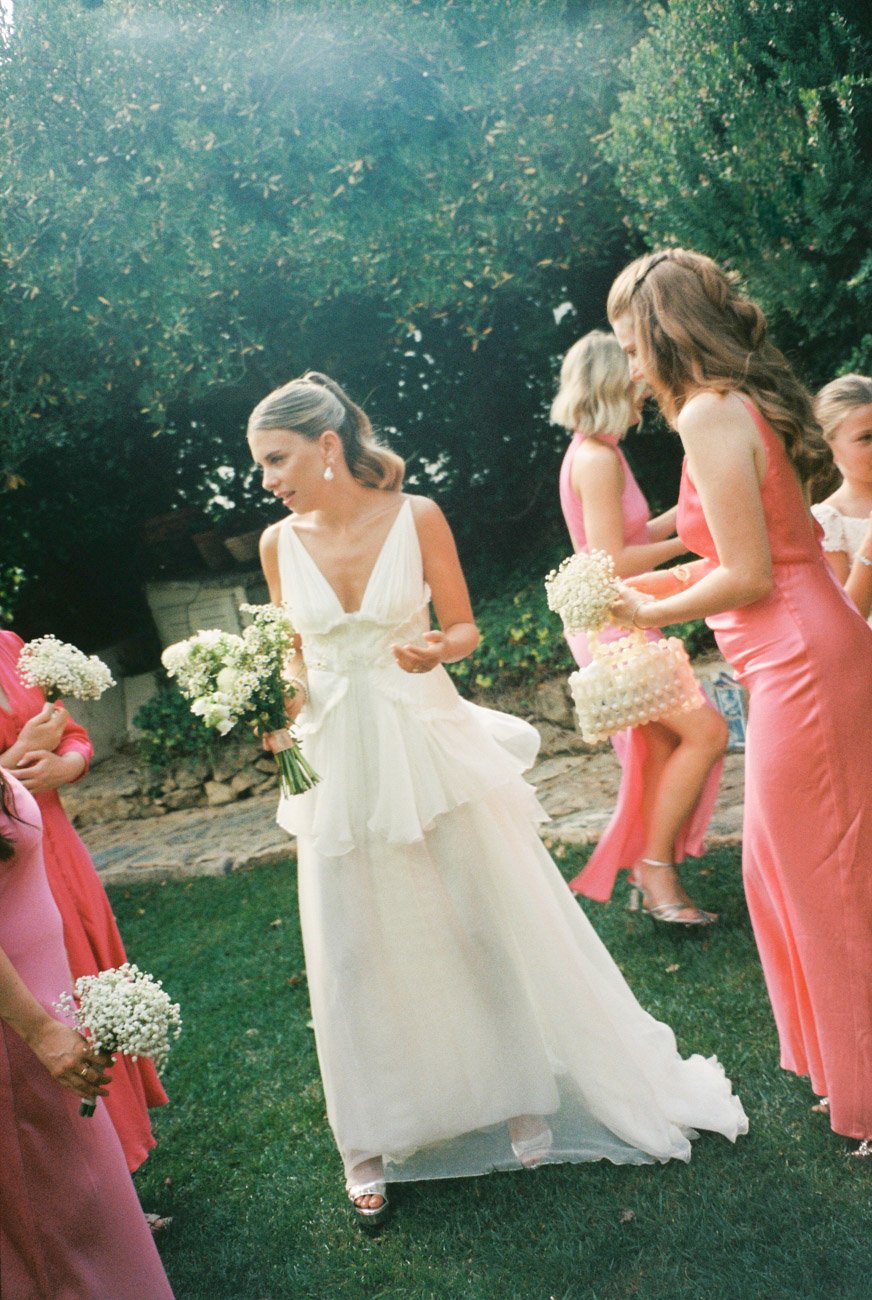 Bridesmaids surrounding the bride before the ceremony in a garden wedding in Casa Sacoto, captured by Lisbon wedding photographer on film.