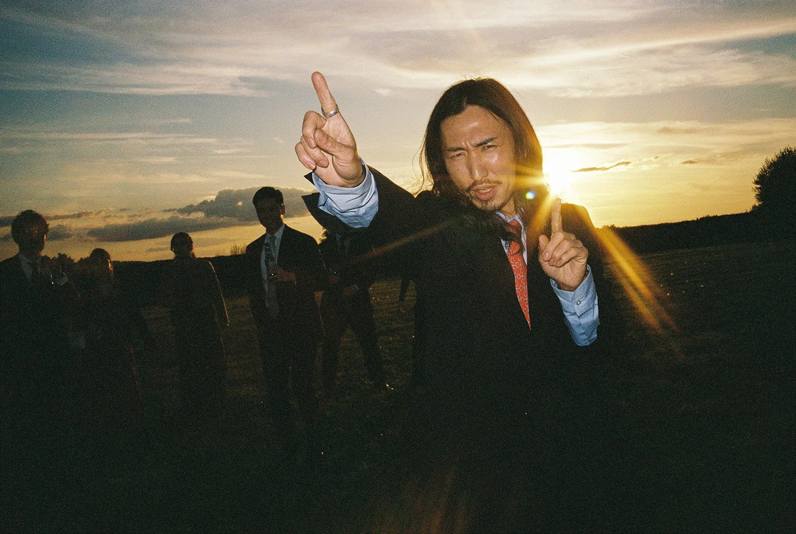 Wedding guest dances at sunset light captured with flash on film.