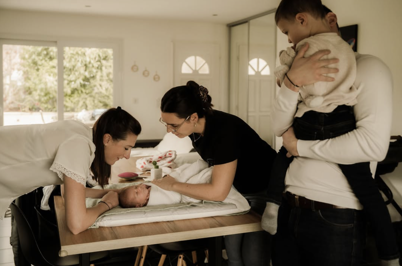 photo de manon qui s'occupe d'un bebe - presence de la maman du papa et du frere. moment de transmission