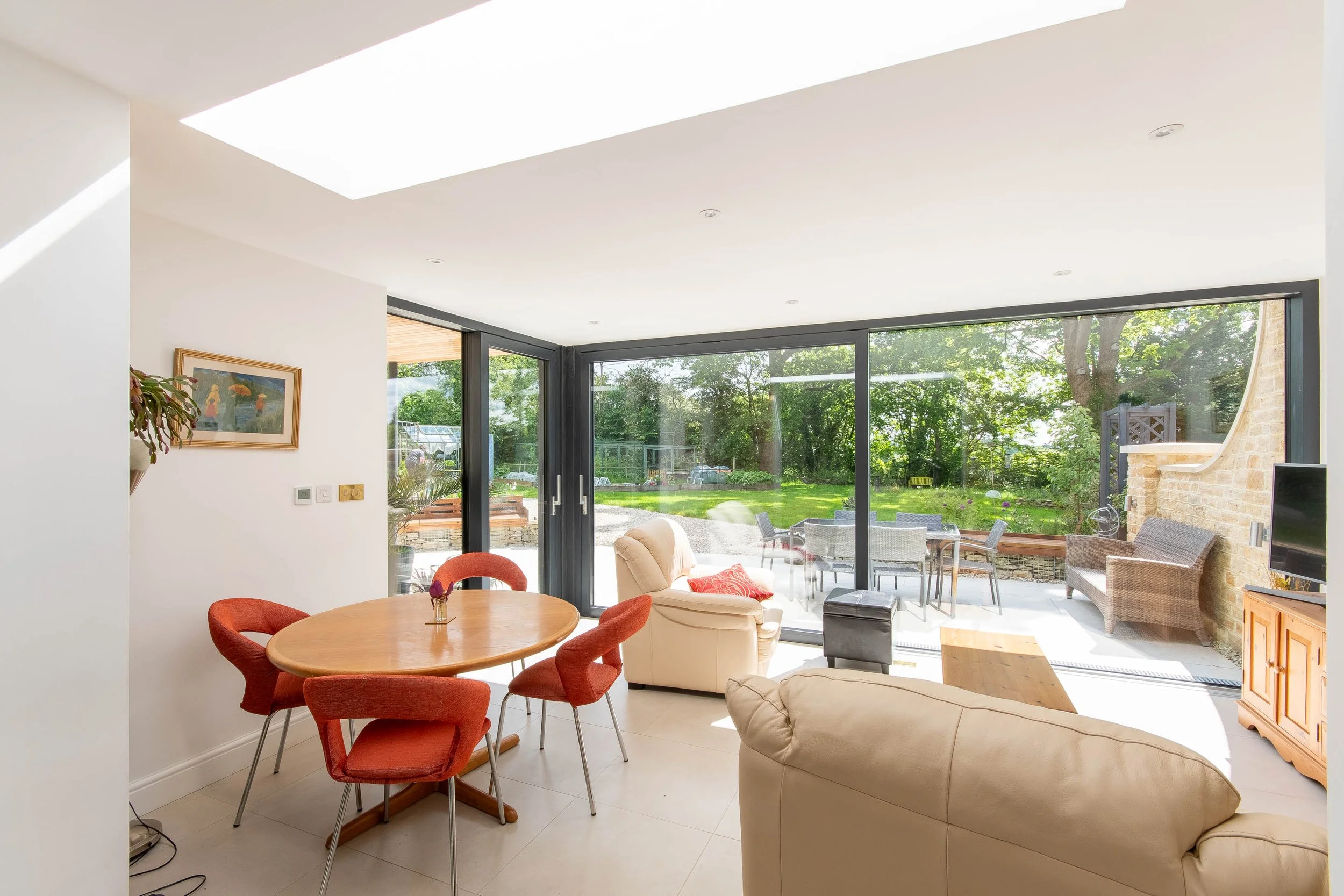 Light-filled contemporary living and dining space looking out onto the landscaped garden.