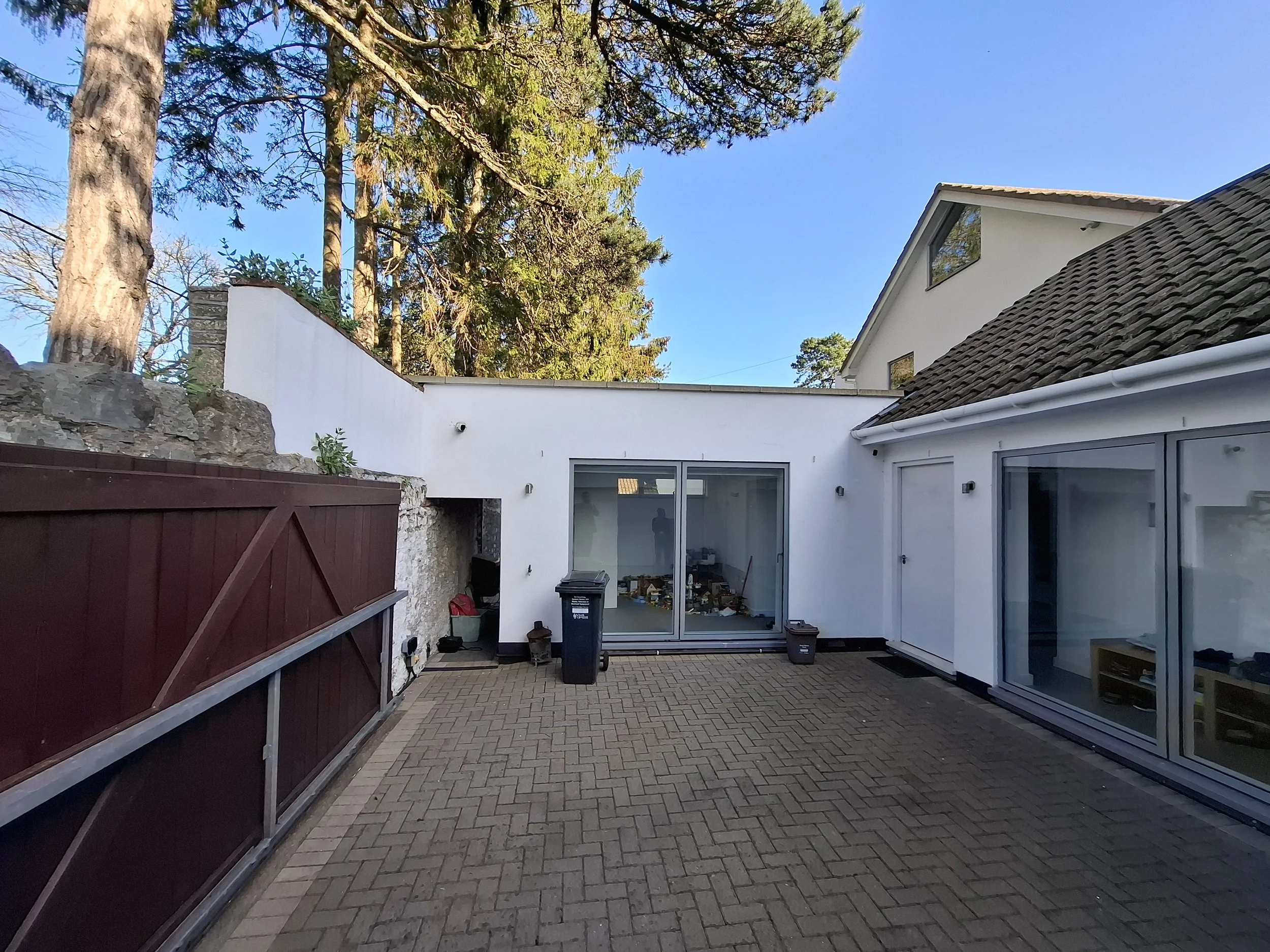 'Before' photograph showing the existing extension and courtyard area.