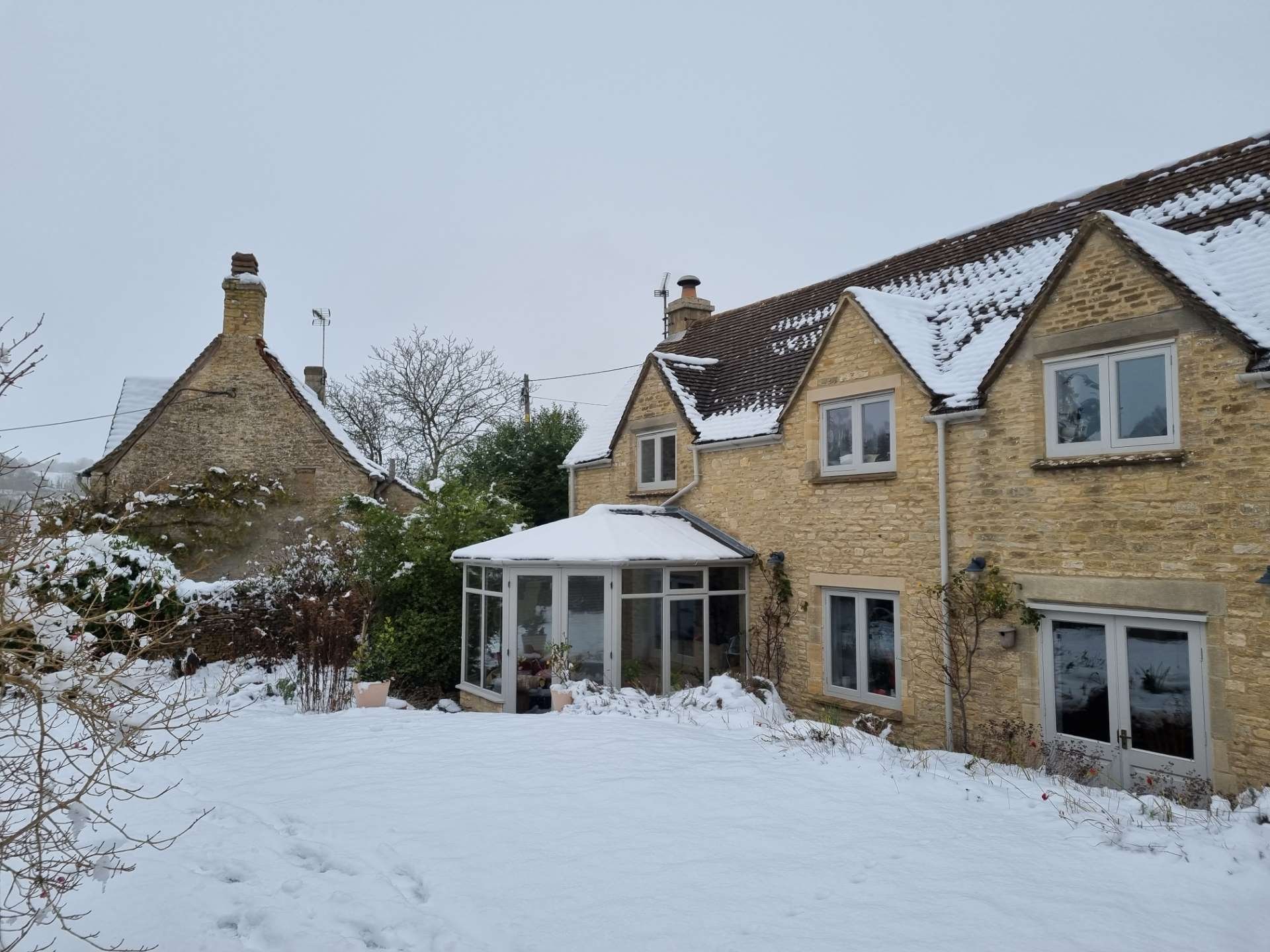 'Before' photograph on a wintry day, showing the existing conservatory, to be replaced.