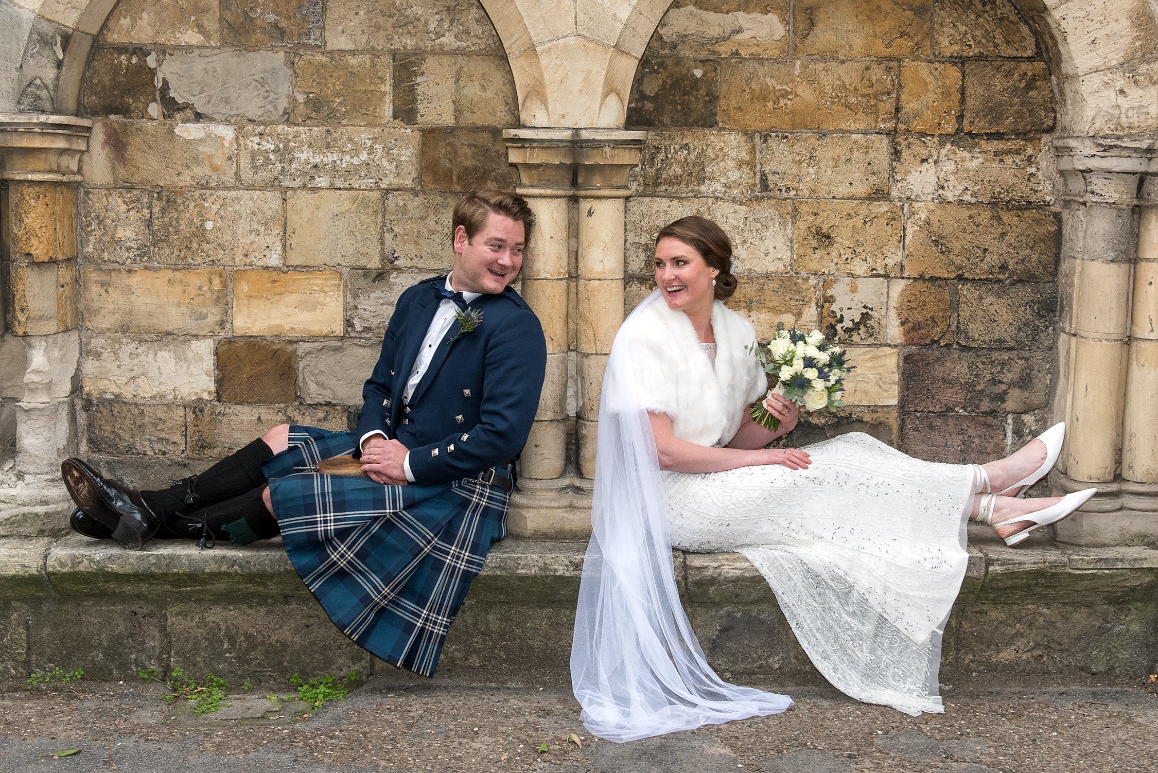 Hamish and Claire posing for fun photos in the Museum Gardens after their wedding at York Register Office.