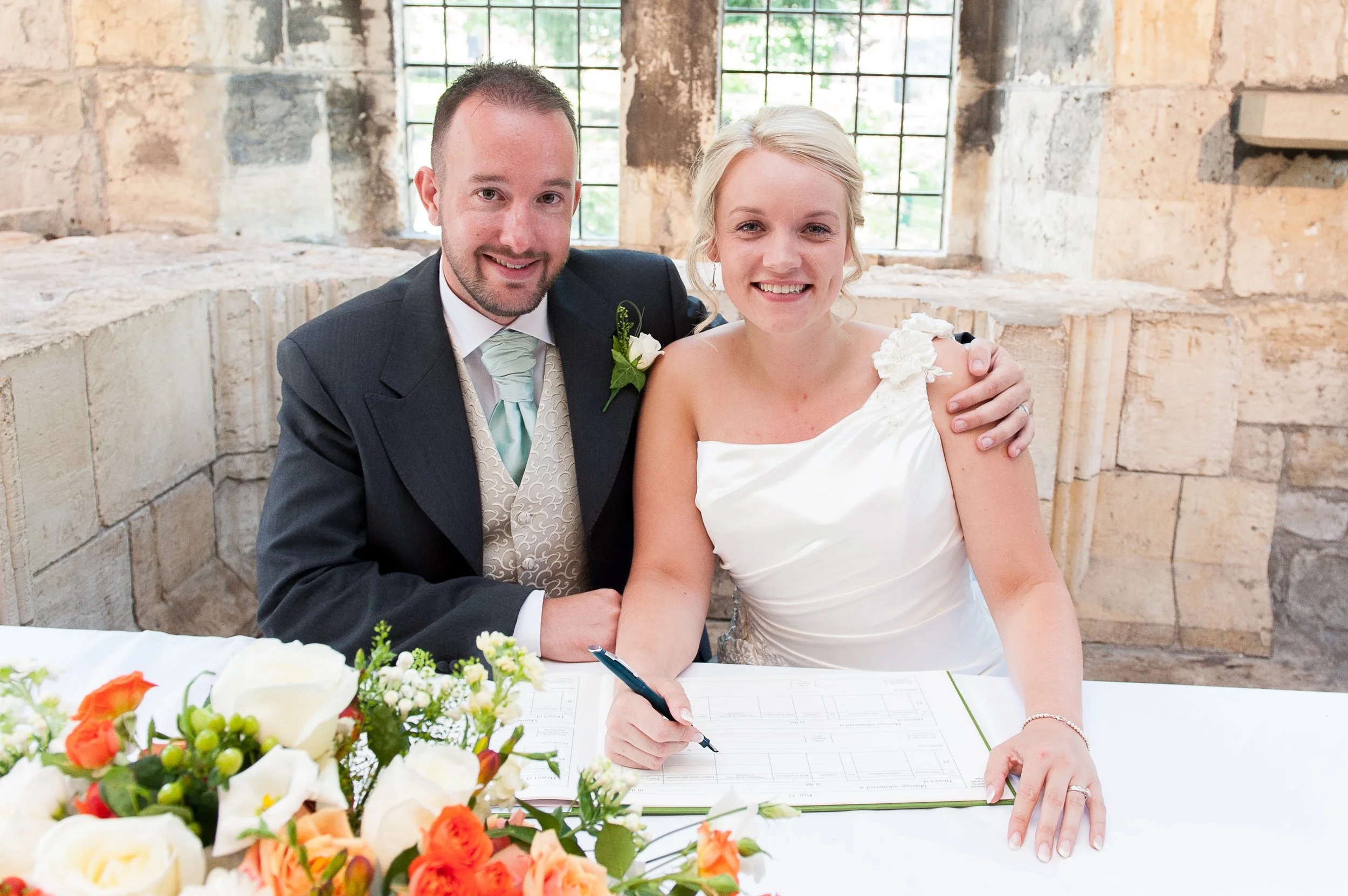 Couple signing the register at The Hospitium wedding venue