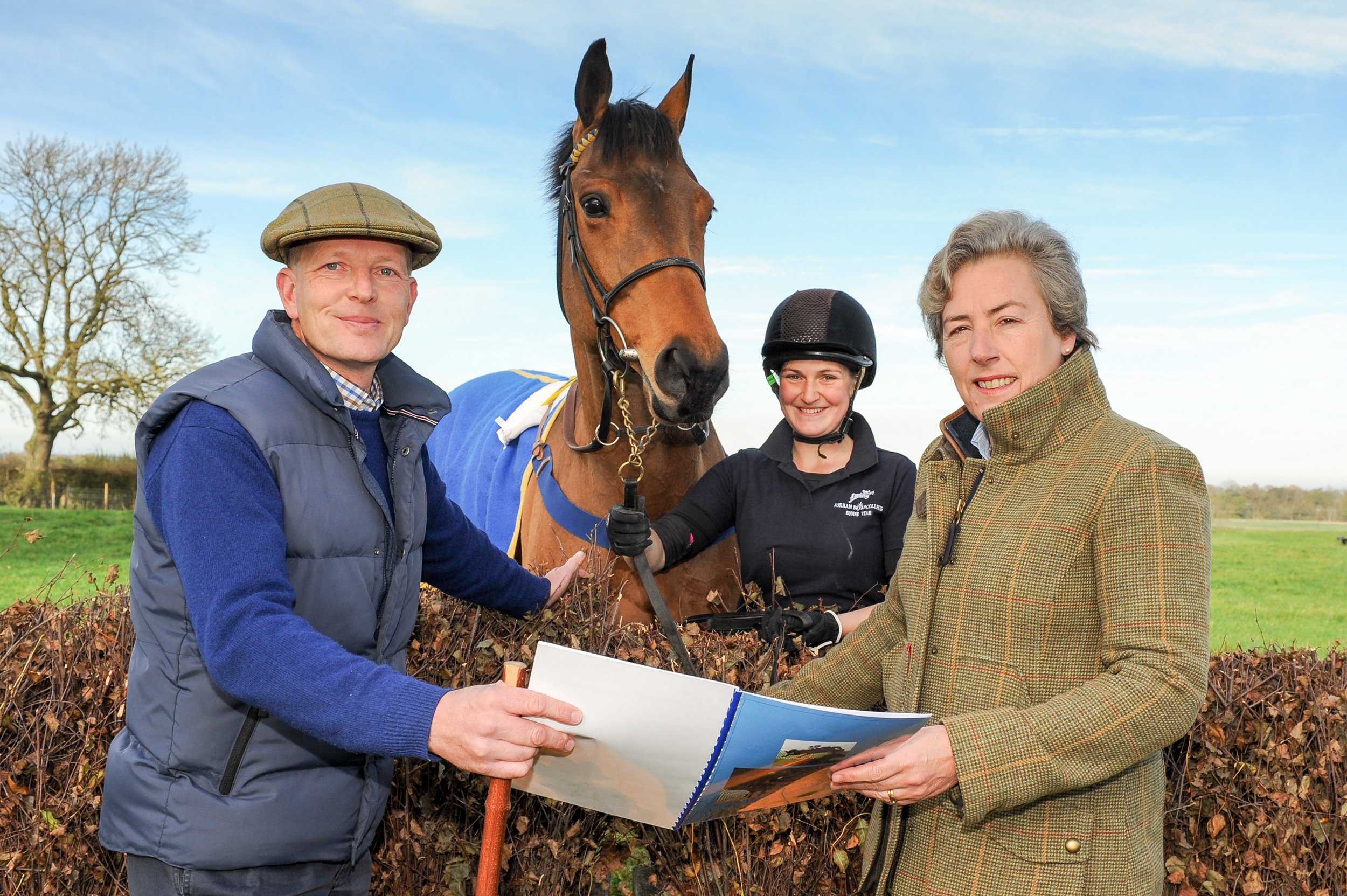 Equestrian plans held by two people watched by horse and rider