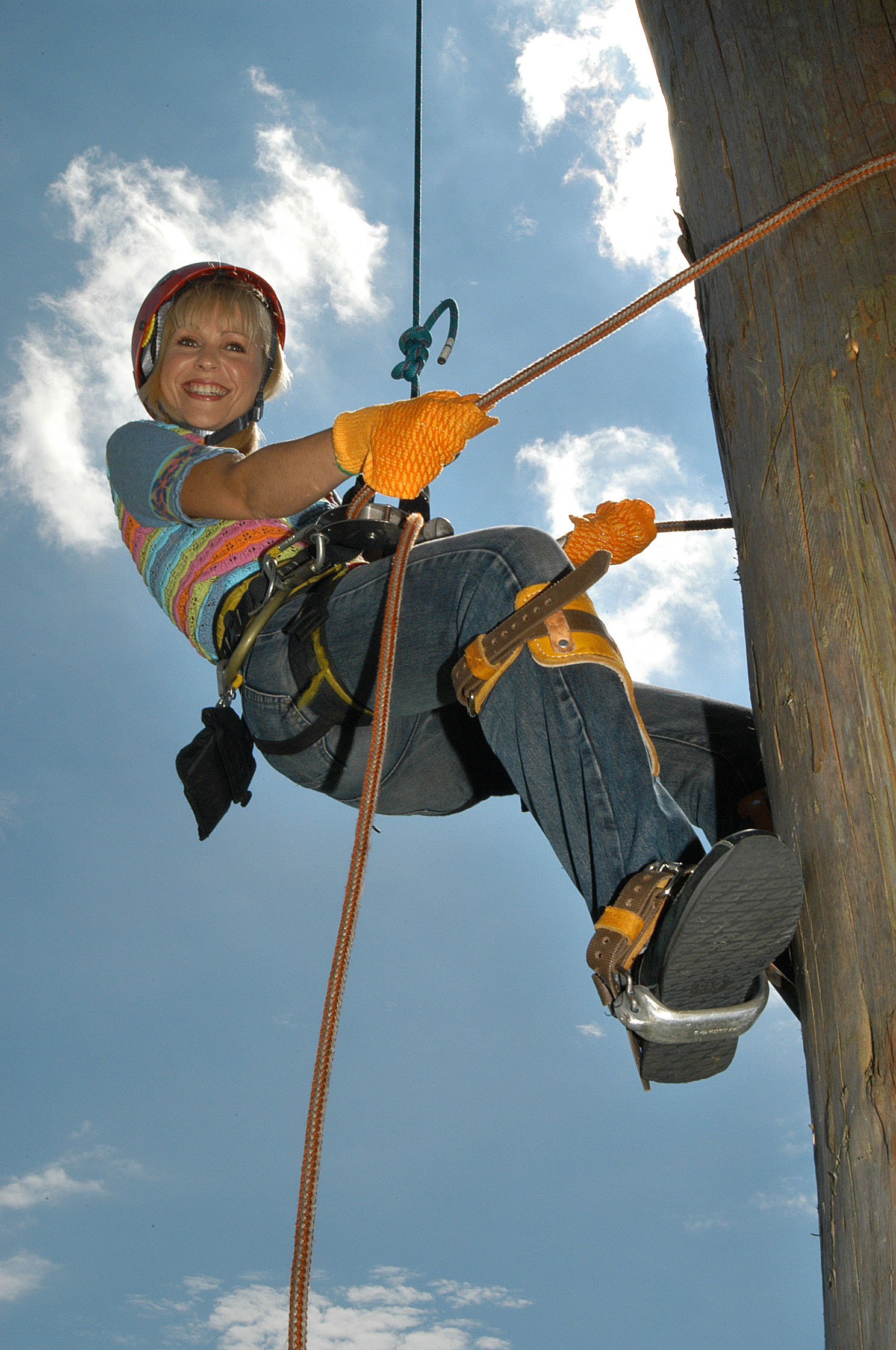 Female TV presenter clmbing a pole