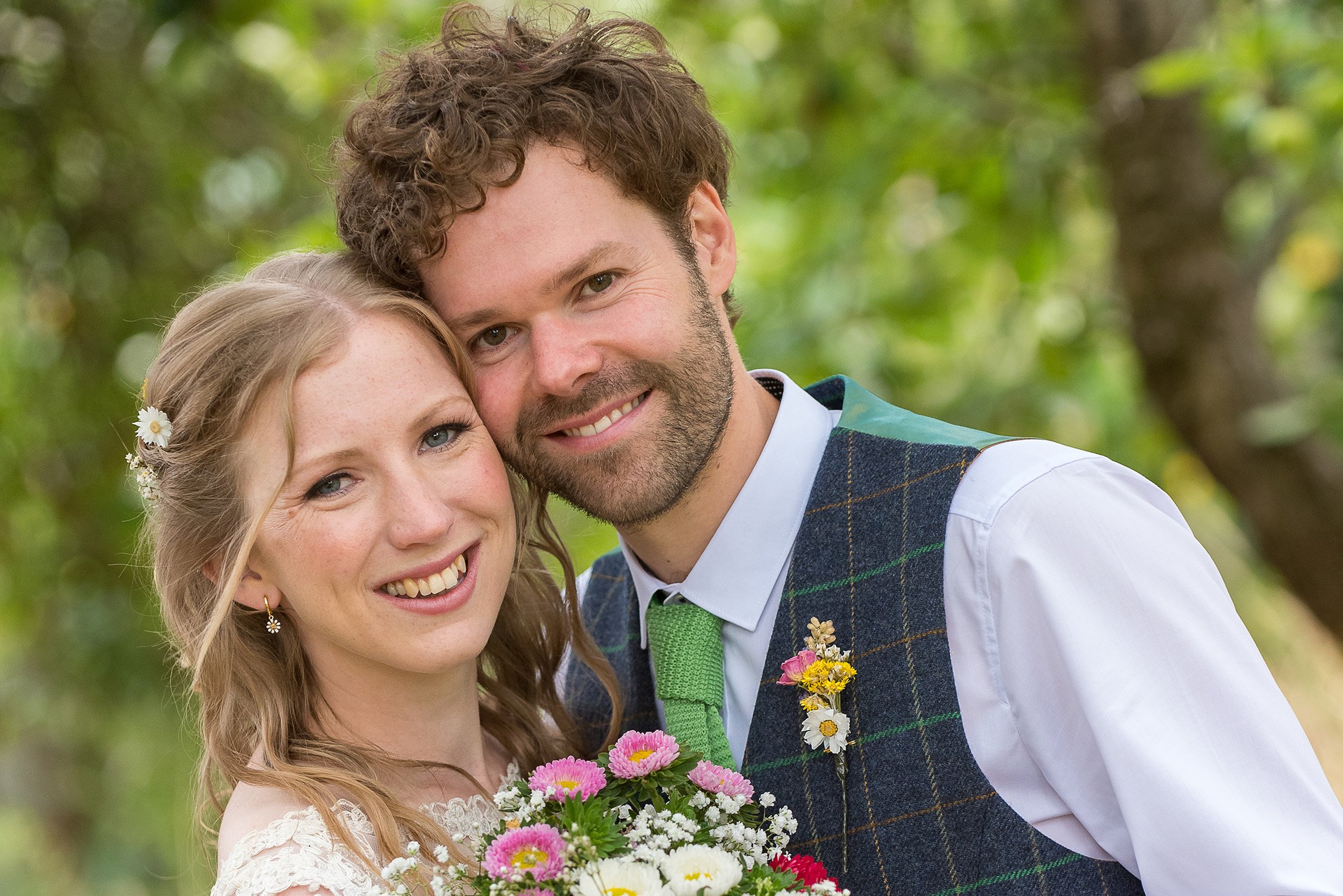 Rebecca & Edward posing for wedding photos in a woodland background