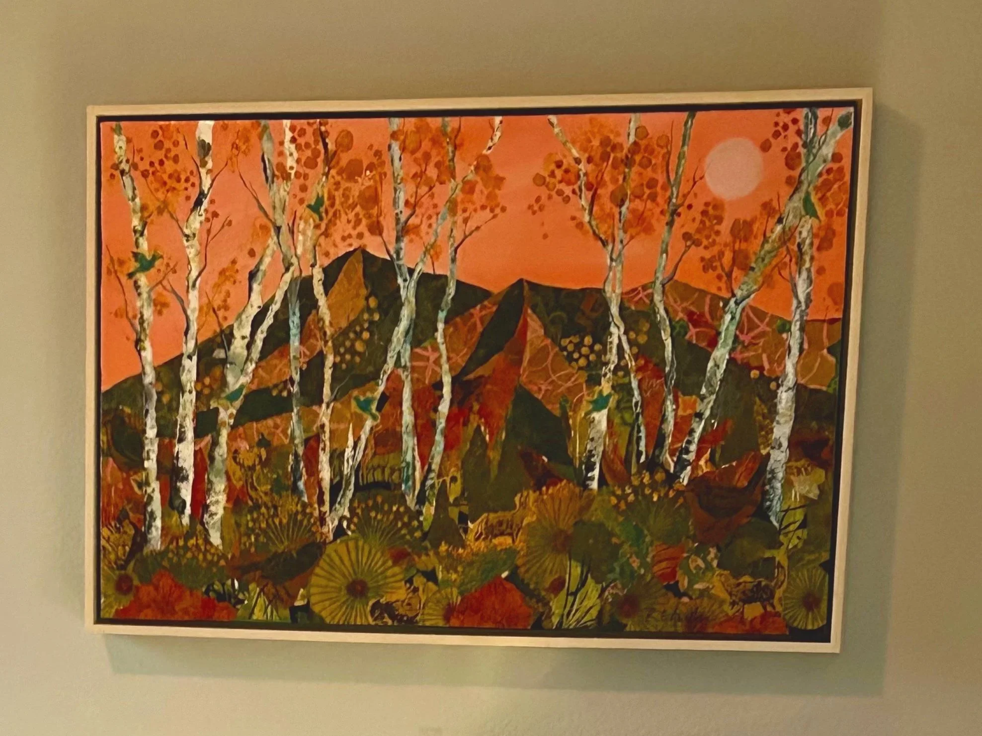 Orange sunset over the mountains with aspen trees in the foreground