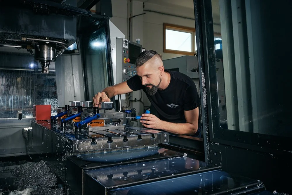 Mann arbeitet an einem CNC-Maschinen-Tool in einer Werkstatt.