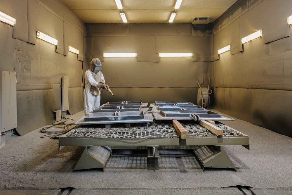 Mitarbeiter in einem Isolationsraum bei der Arbeit mit Metallplatten.