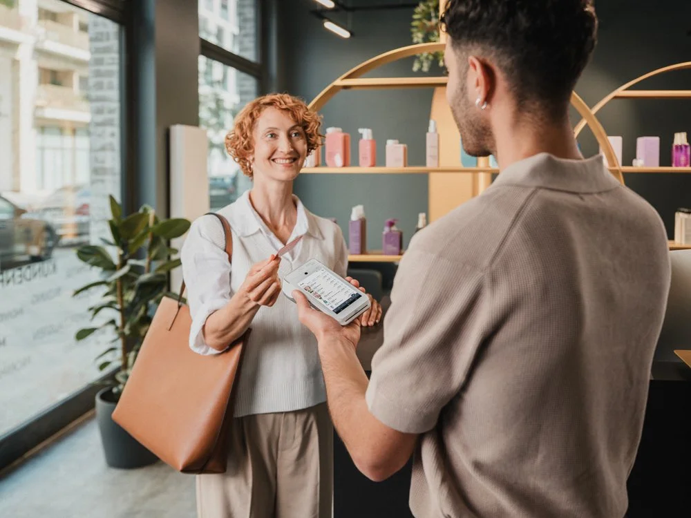 Eine Frau im Gespräch mit einem Verkäufer in einem Laden, in dem Pflegeprodukte verkauft werden.