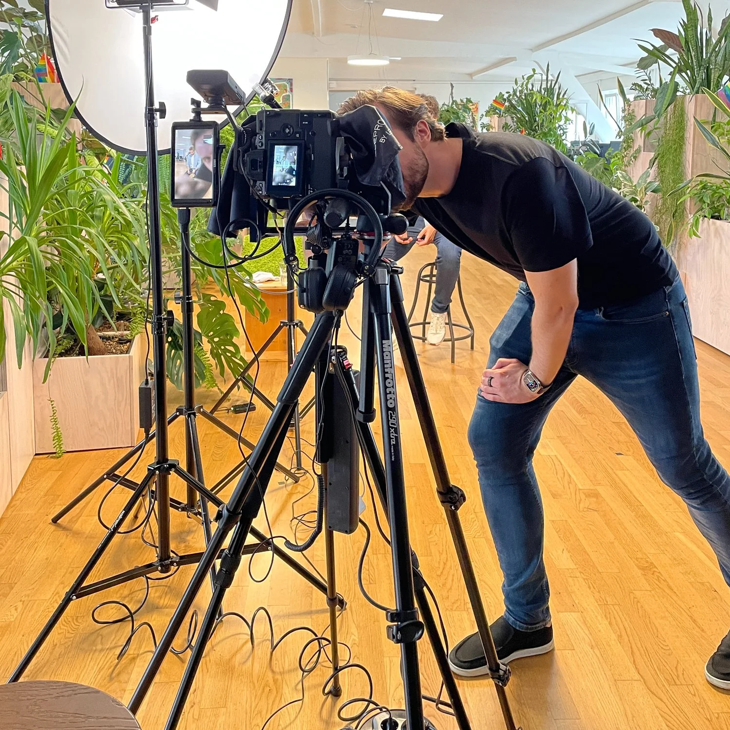 Ein Mann beim Filmen in Innenraum mit vielen Pflanzen.