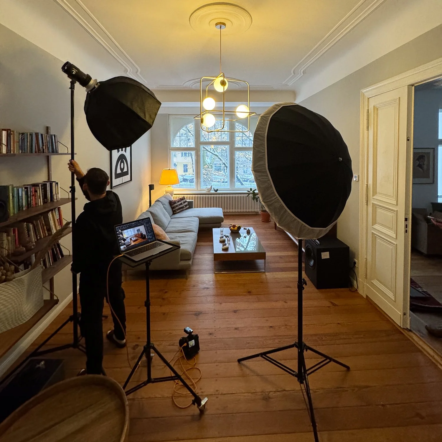 Fotostudio in einem Wohnzimmer mit professioneller Beleuchtung und einem Fotografen, der Bilder macht.