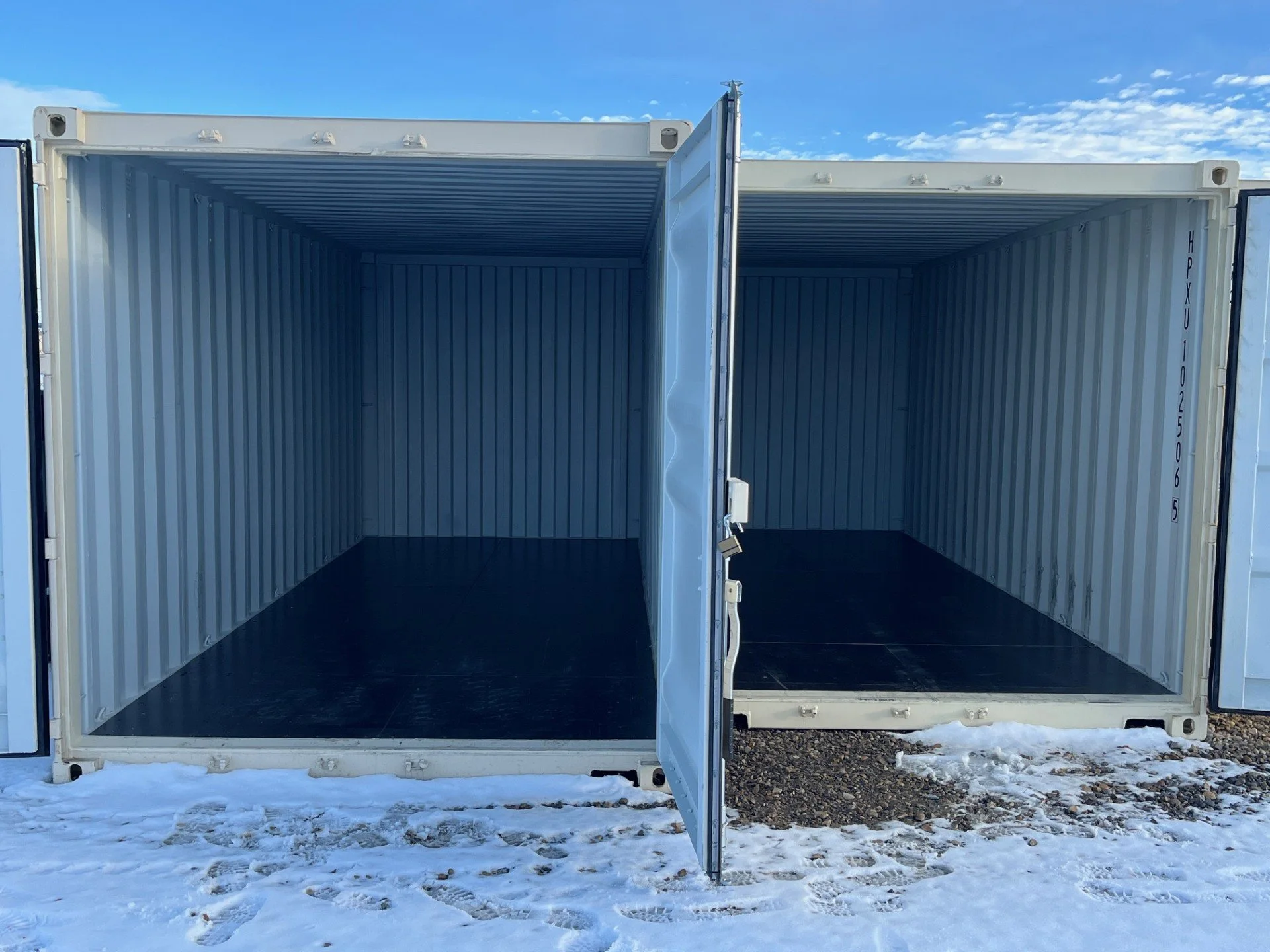 Great West Storage - Two empty shipping containers open on a snowy ground with a blue sky background.