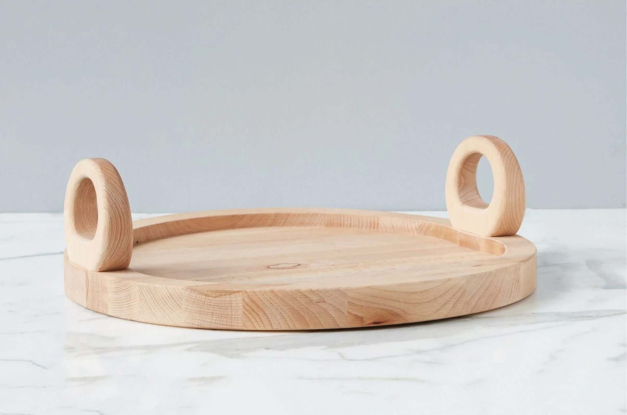  Bring a modern aesthetic and simple lines to the table with the  Belgian Round Chopping Tray . Made from beech wood sourced in Europe, with two wooden handles that make it easy to move, it can be used both as a chopping board and a serving platter. 