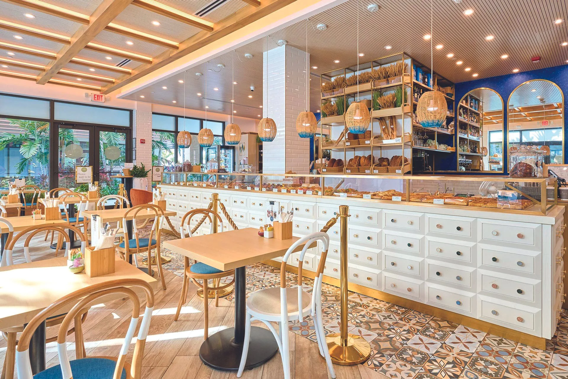 Two women in a warm, well-lit kitchen, smiling and holding white paper towels, engaging in a baking or cooking activity.