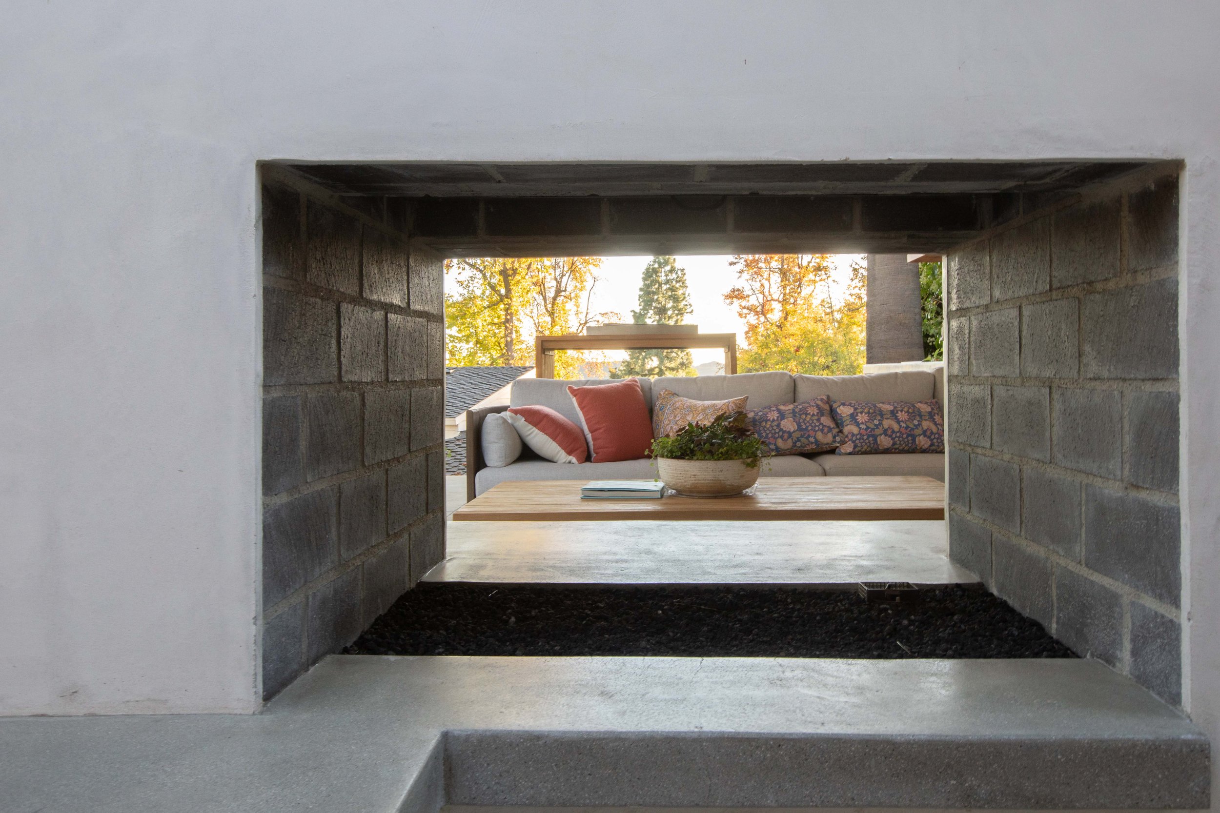 Double-sided outdoor fireplace, view through firebox to seating area, cedar pavilion La Cañada Flintridge