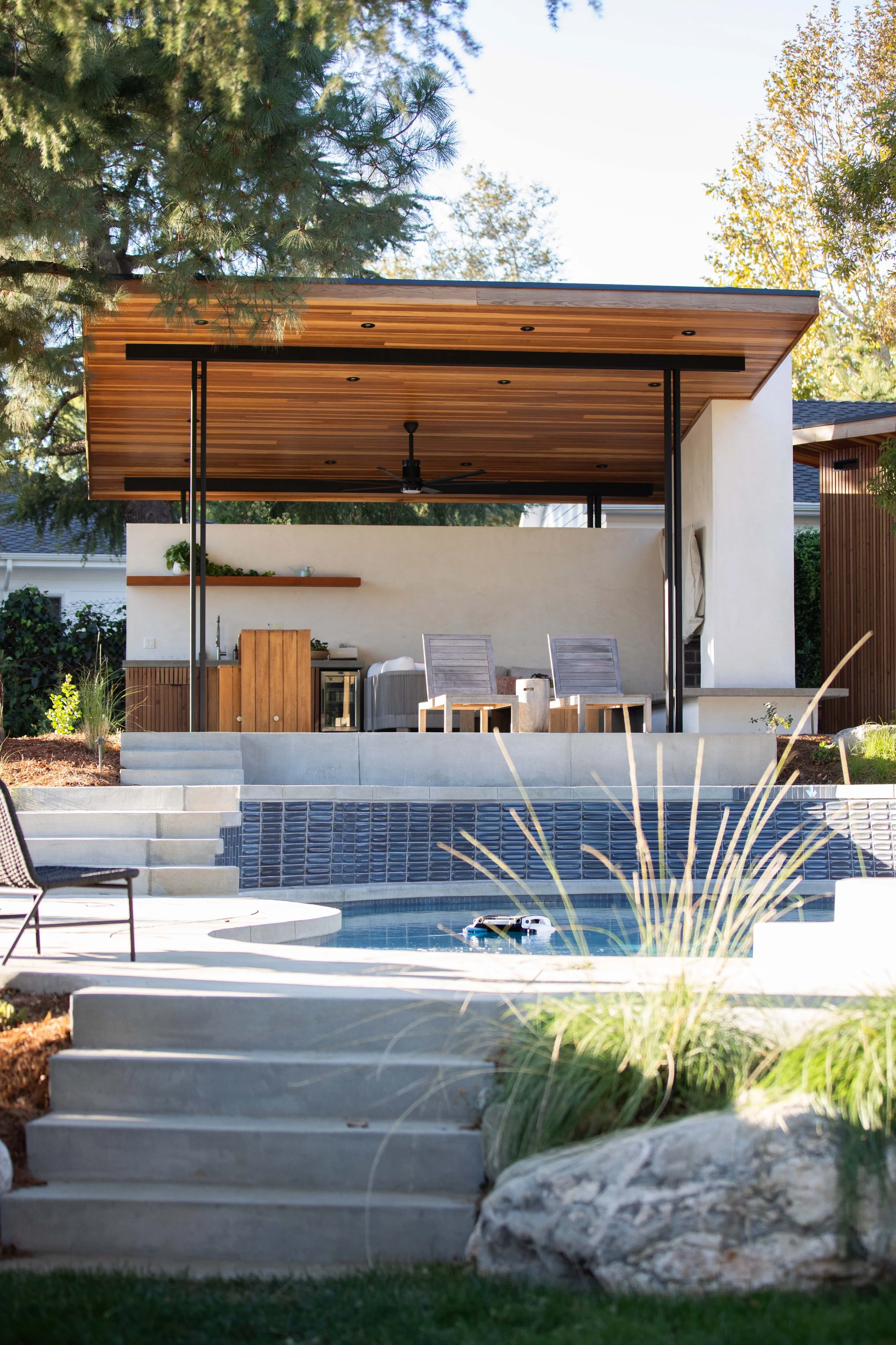 Outdoor pavilion with cedar roof, pool surround and boulder planting, La Cañada Flintridge, CRAFT Landscape Architecture