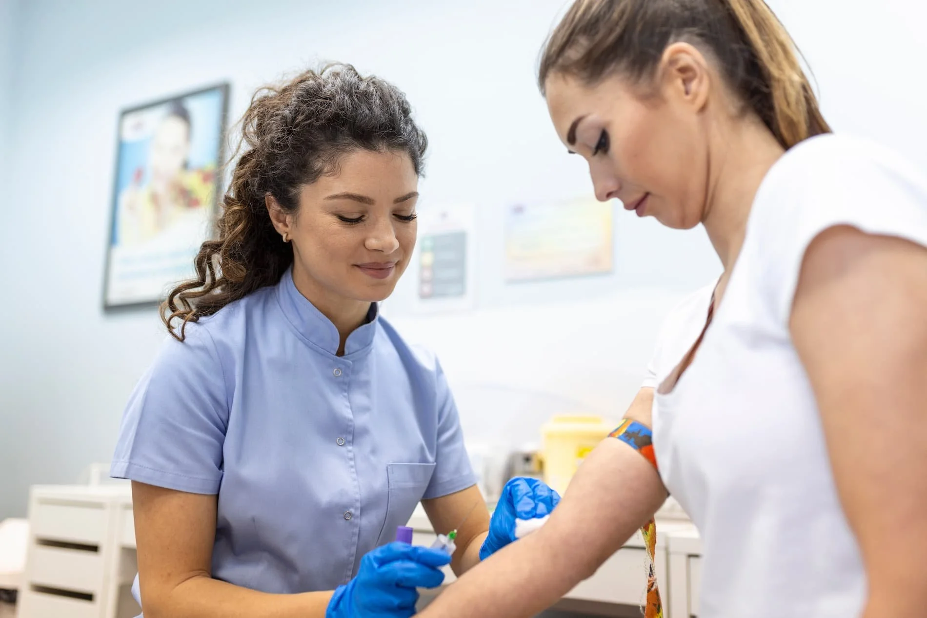 Lab technician drawing a blood sample from a patient during baseline hormone and metabolic testing.