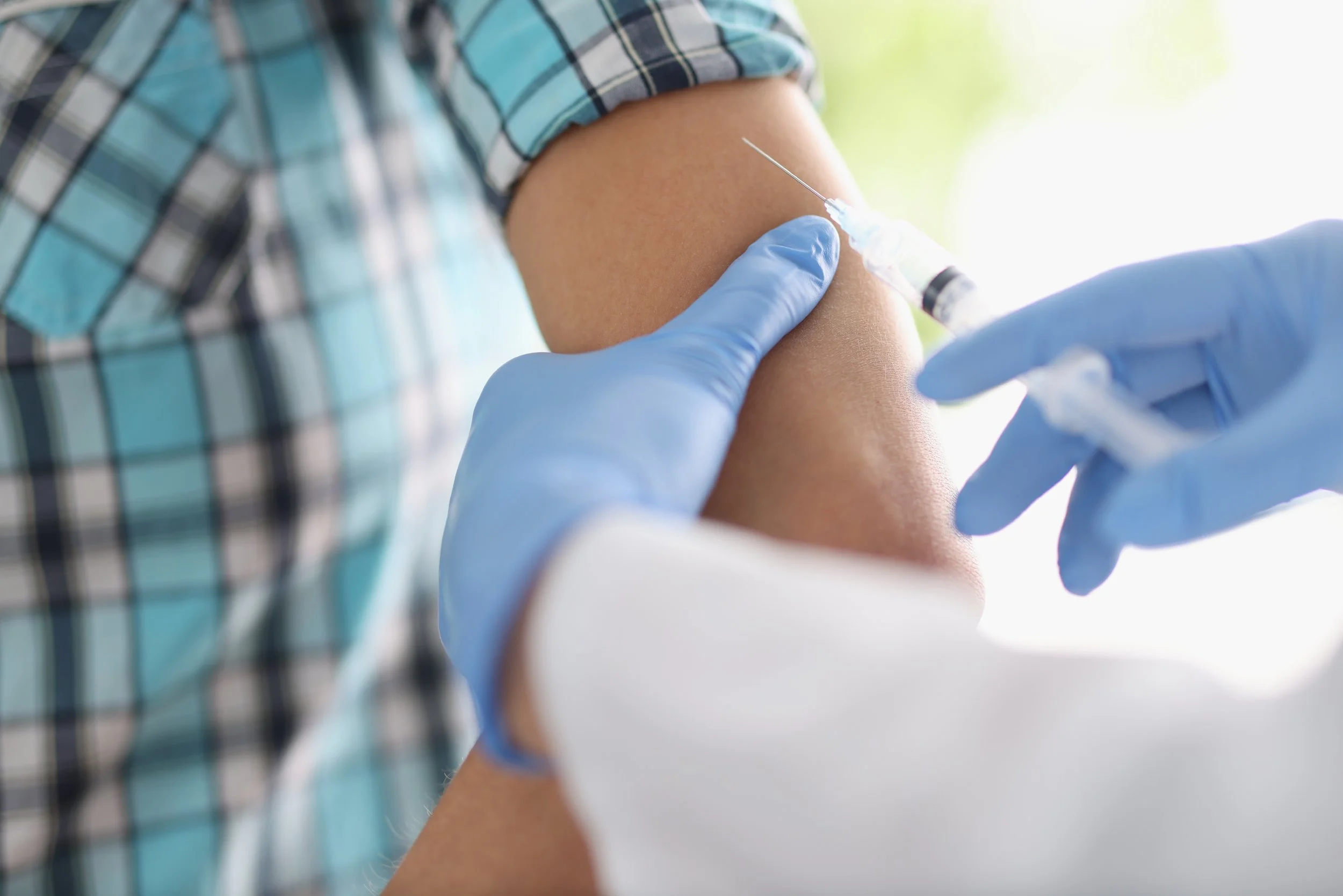 Healthcare provider administering a weight loss injection into a patient’s upper arm.