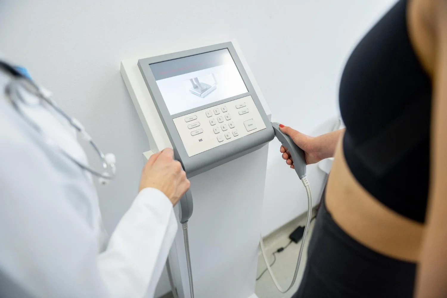 Medical technician assisting a patient with a body composition analysis machine during a weight loss program assessment.