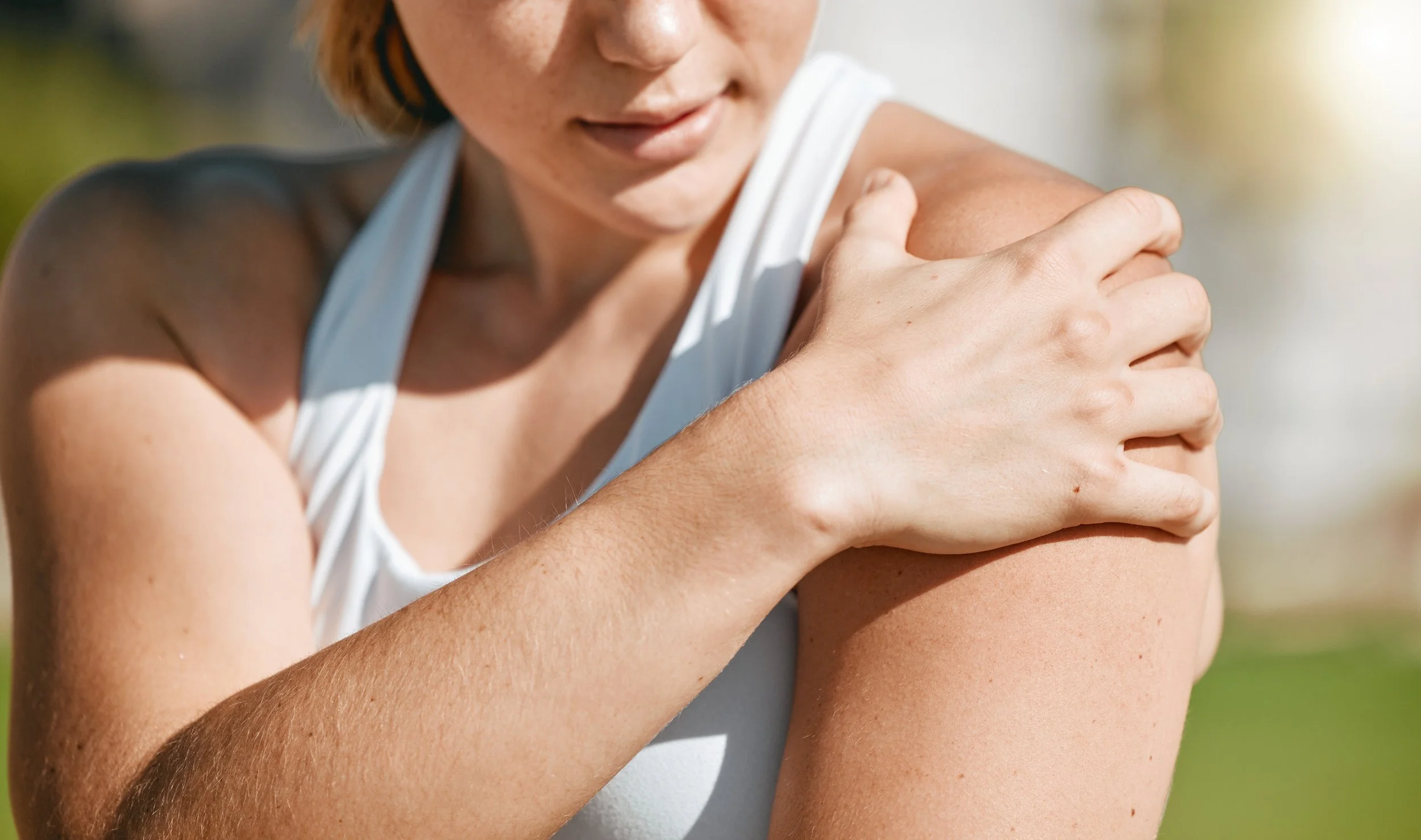 Woman holding shoulder joint after exercise, illustrating recovery and inflammation that BPC-157 peptide research targets