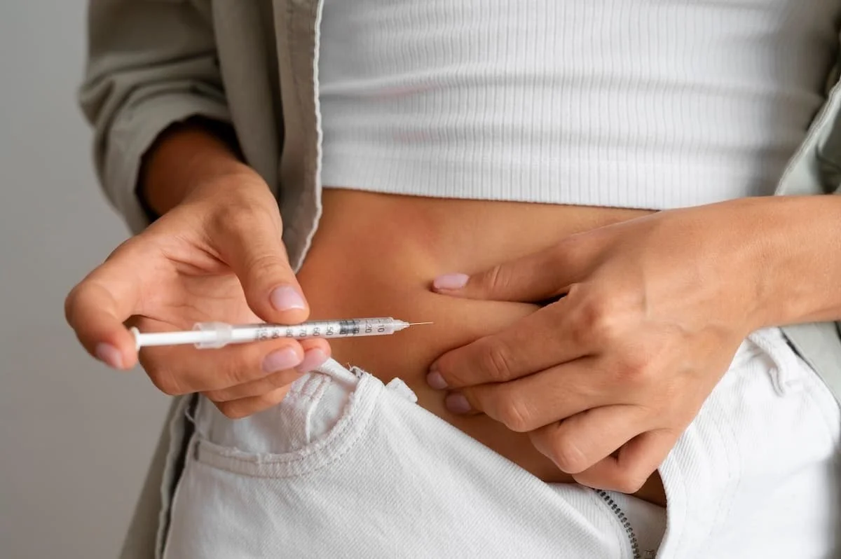 Person administering a weekly weight loss injection, illustrating semaglutide or tirzepatide treatment supervised by a medical provider