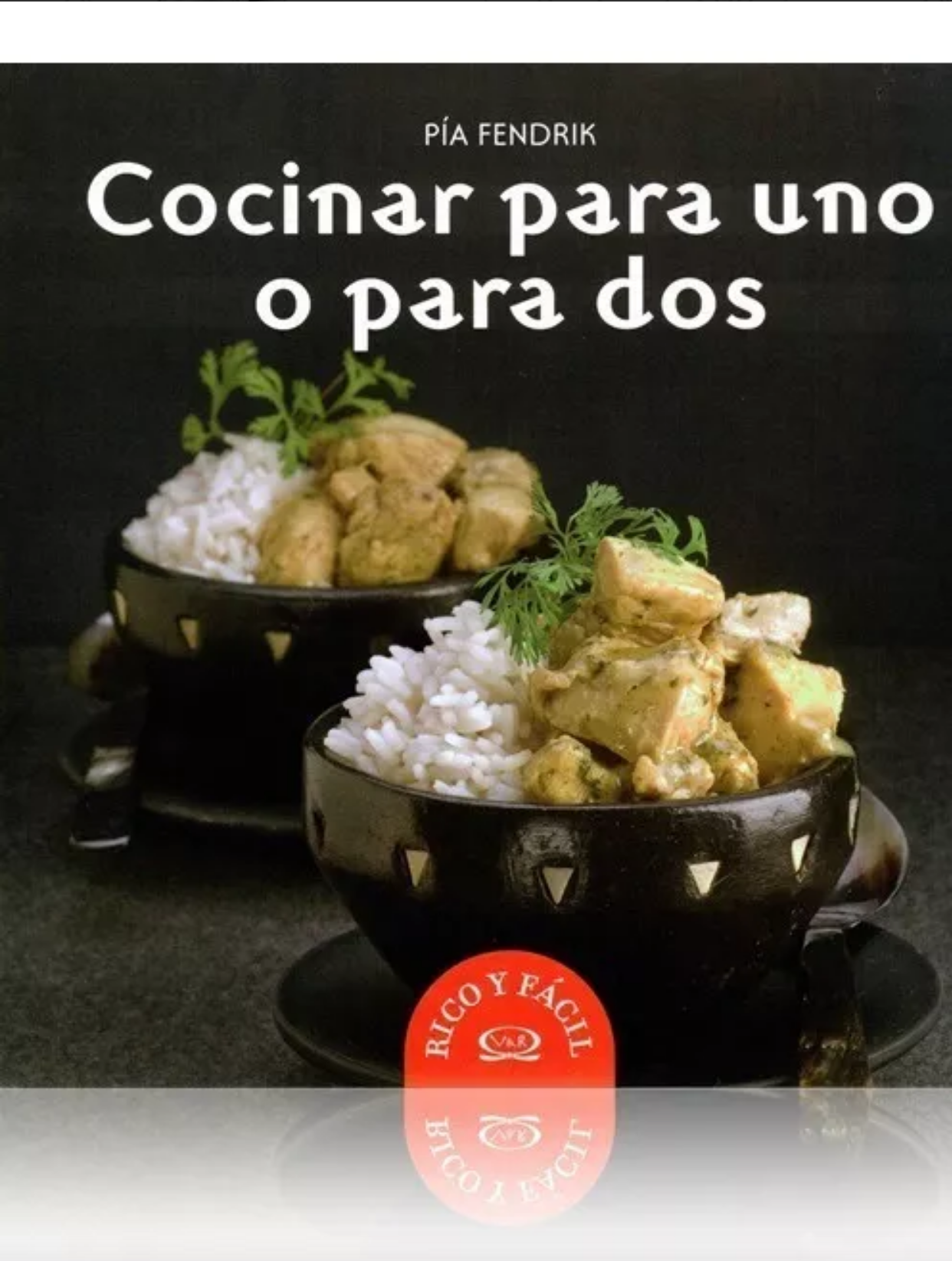 Portada de libro con dos platos de comida, uno con pollo y arroz, y el otro con comida similar, decorados con perejil, en plato negro. Título: 'Cocinar para uno o para dos' de Pía Fendrik.